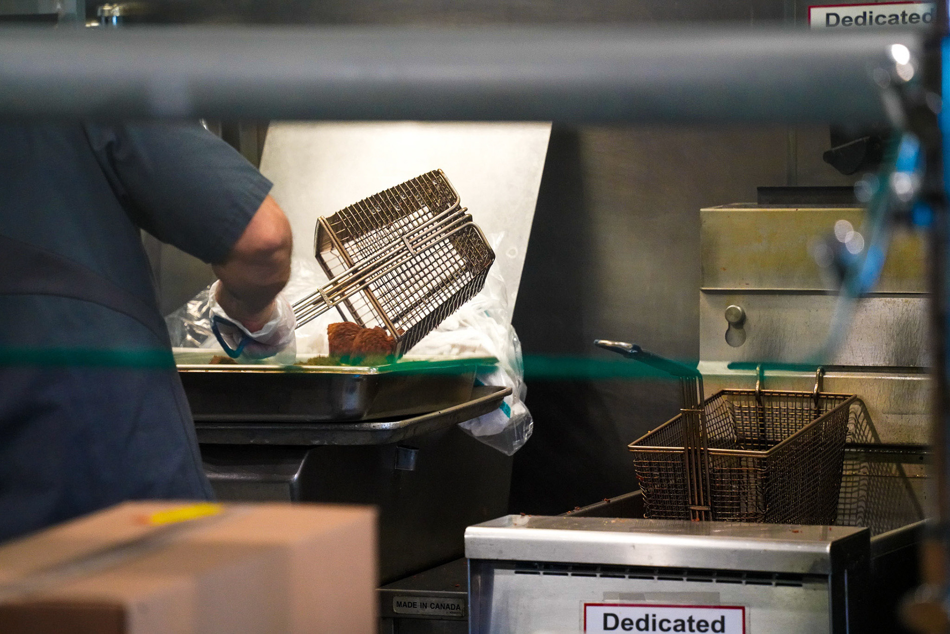 Commons worker Joe pours a basket of falafel into the dedicated fryer located at the vegan bar.