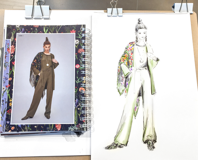 Eine handgezeichnete Modeillustration die eine stehende Frau zeigt.  Sie hat einen olivgrünen Overall (Einteiler) und Schuhe in Schlangenlederoptik. Über die Schultern liegt ein bunt gemustertes Tuch mit floralem Muster. Sie trägt lange Ohrringe in schwarz und eine lange Kette mit Anhänger. Der Look zeigt ein Outfit das von der Modemarke RIANI kreiert wurde. Die Mode Skizze wurde von der Illustratorin Anna Schwarzer für einen RIANI Event in Münster im LEY´s gezeichnet.  Fashion illustration showing a woman standing wearing a olive green oonesie (overall) and shoes in the look of snakeskin. She wears black long earrings and a long necklace. Over her shoulders lays a large scarf with a colorful floral print. The look is an outfit created by the fashion brand RIANI. The illustration was created by illustrator Anna Schwarzer for an RIANI event at LEY´s in Muenster.