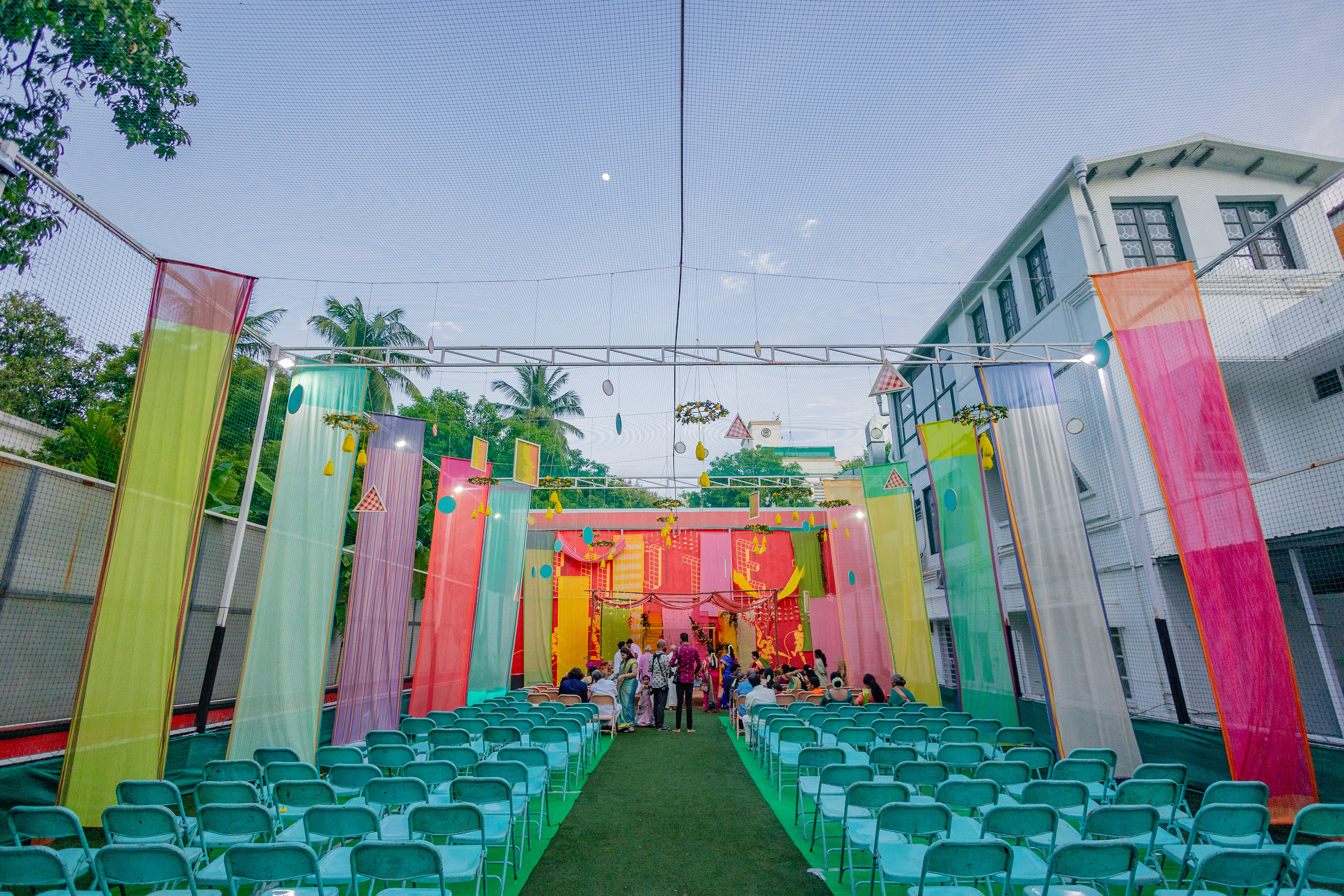 Panels of fabric were tailored to size and hung to form the base over which we built details like woven thread wooden frames, colourful floral arrangements with highlights like heliconia flowers, and a scalloped ceiling.