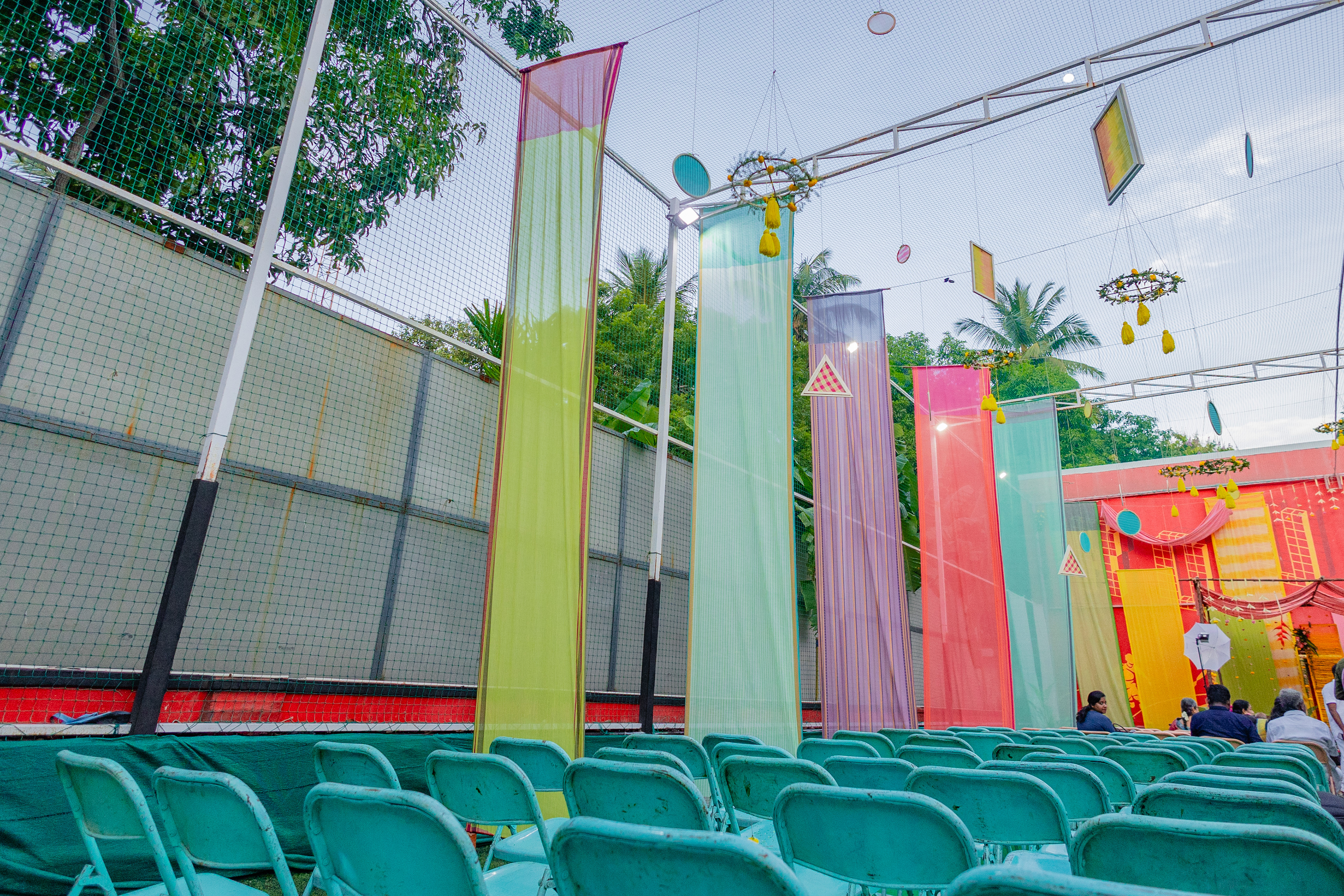 Panels of fabric were tailored to size and hung to form the base over which we built details like woven thread wooden frames, colourful floral arrangements with highlights like heliconia flowers, and a scalloped ceiling.