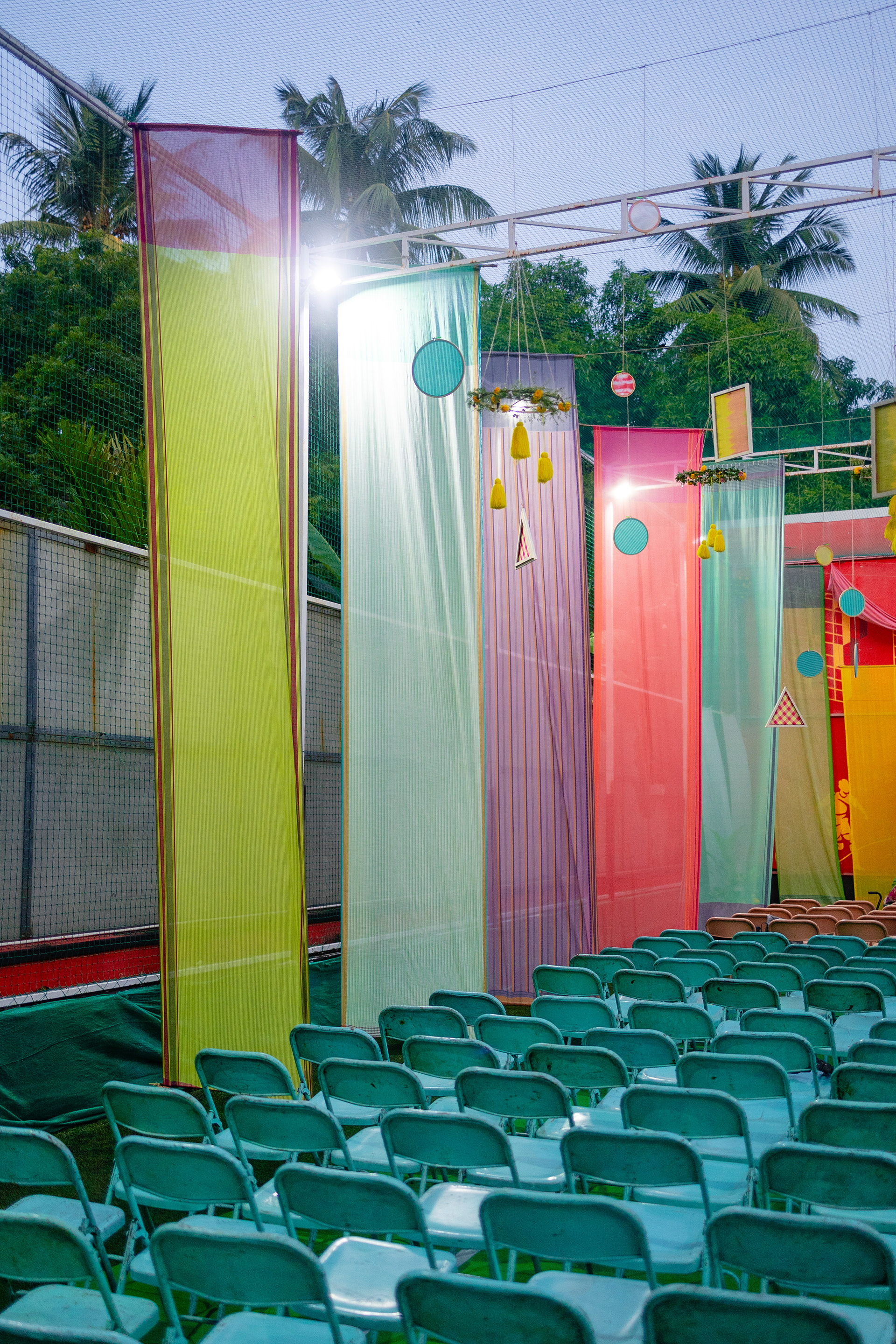 Panels of fabric were tailored to size and hung to form the base over which we built details like woven thread wooden frames, colourful floral arrangements with highlights like heliconia flowers, and a scalloped ceiling.