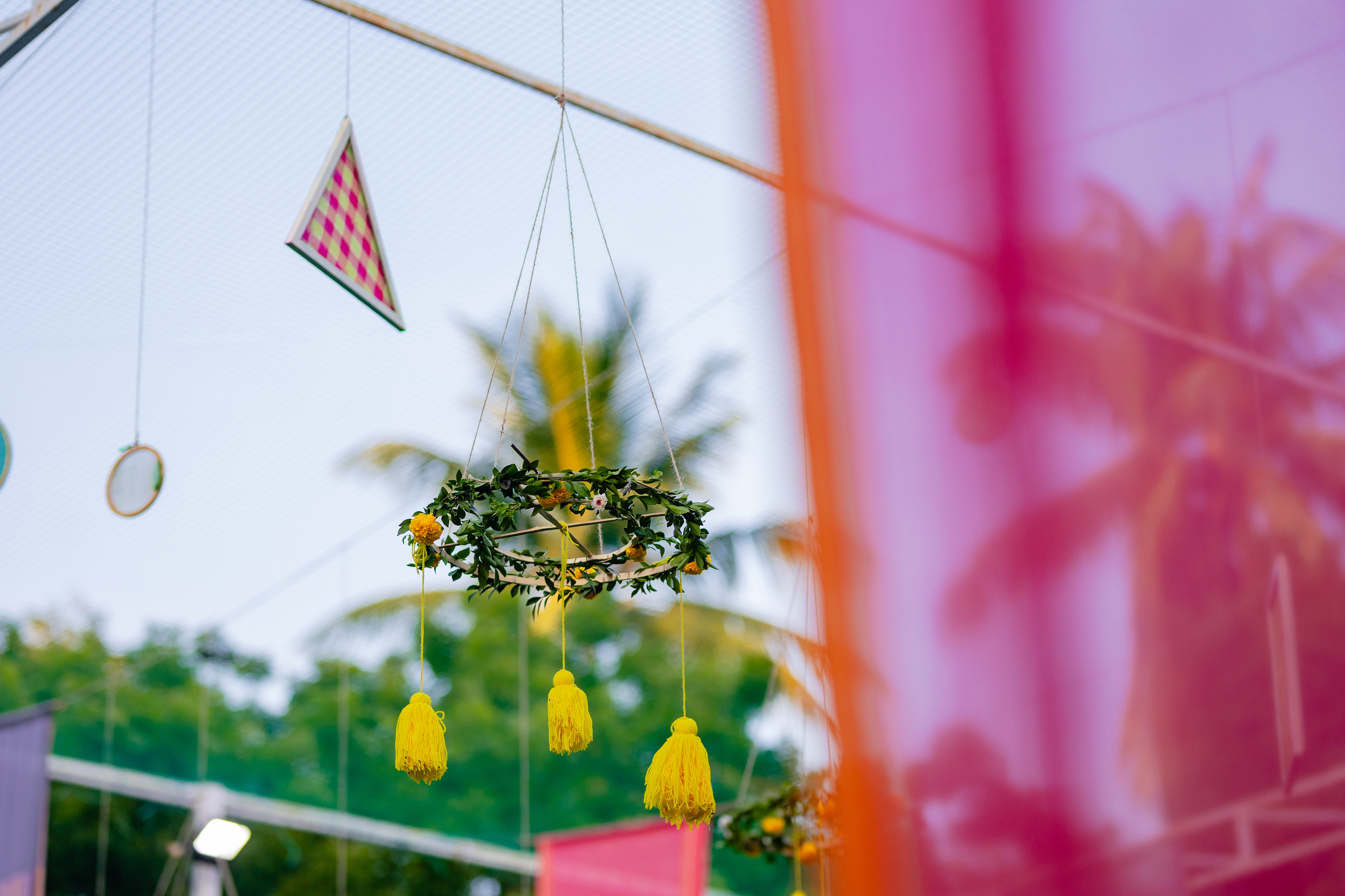 The ceiling was filled with whimsical hanging decor details, like more fabric frames, embroidery hoops with gauzy fabric and leafy chandeliers with popping yellow tassels.