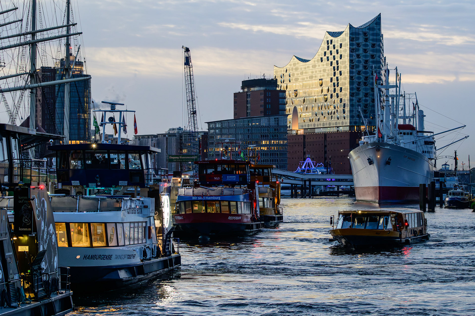 Die 2017 eröffnete Elbphilharmonie Hamburg wurde in kürzester Zeit zu dem bekanntesten Wahrzeichen der Hansestadt. Sie thront über dem Hafen, in dem neben den Hafenfähren auch einige Museumsschiffe liegen, wie z.B. der 1962 erbaute Stückgutfrachter Cap San Diego (rechts im Bild).