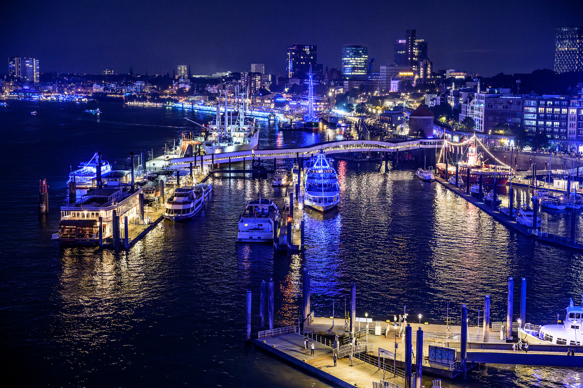 Der renommierte Lichtkünstler Michael Batz läßt alle zwei Jahre im Rahmen seines Kunstprojekts "Blue Port Hamburg" den Hamburger Hafen in blaues Licht tauchen. Hier sehen wir die Überseebrücke und die St. Pauli Landungsbrücken von der Aussichtsplattform der Elbphilharmonie aus.