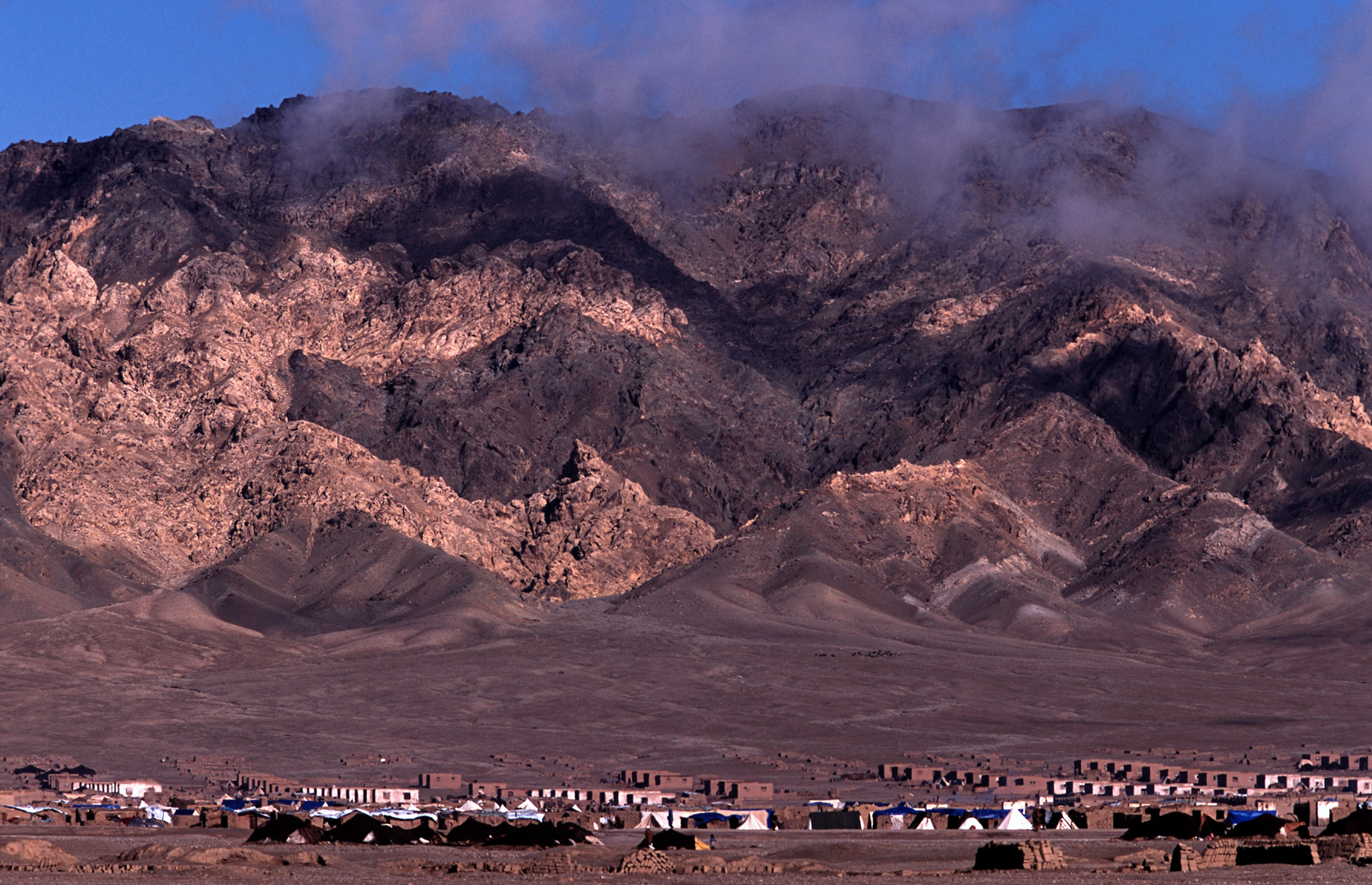Scattered light over the Hindu Kush with refugee camp, Herat, Afghanistan