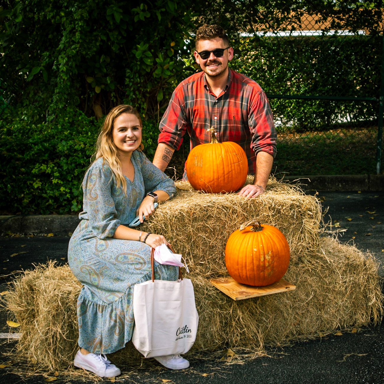 Couple posing on a bail of hay.