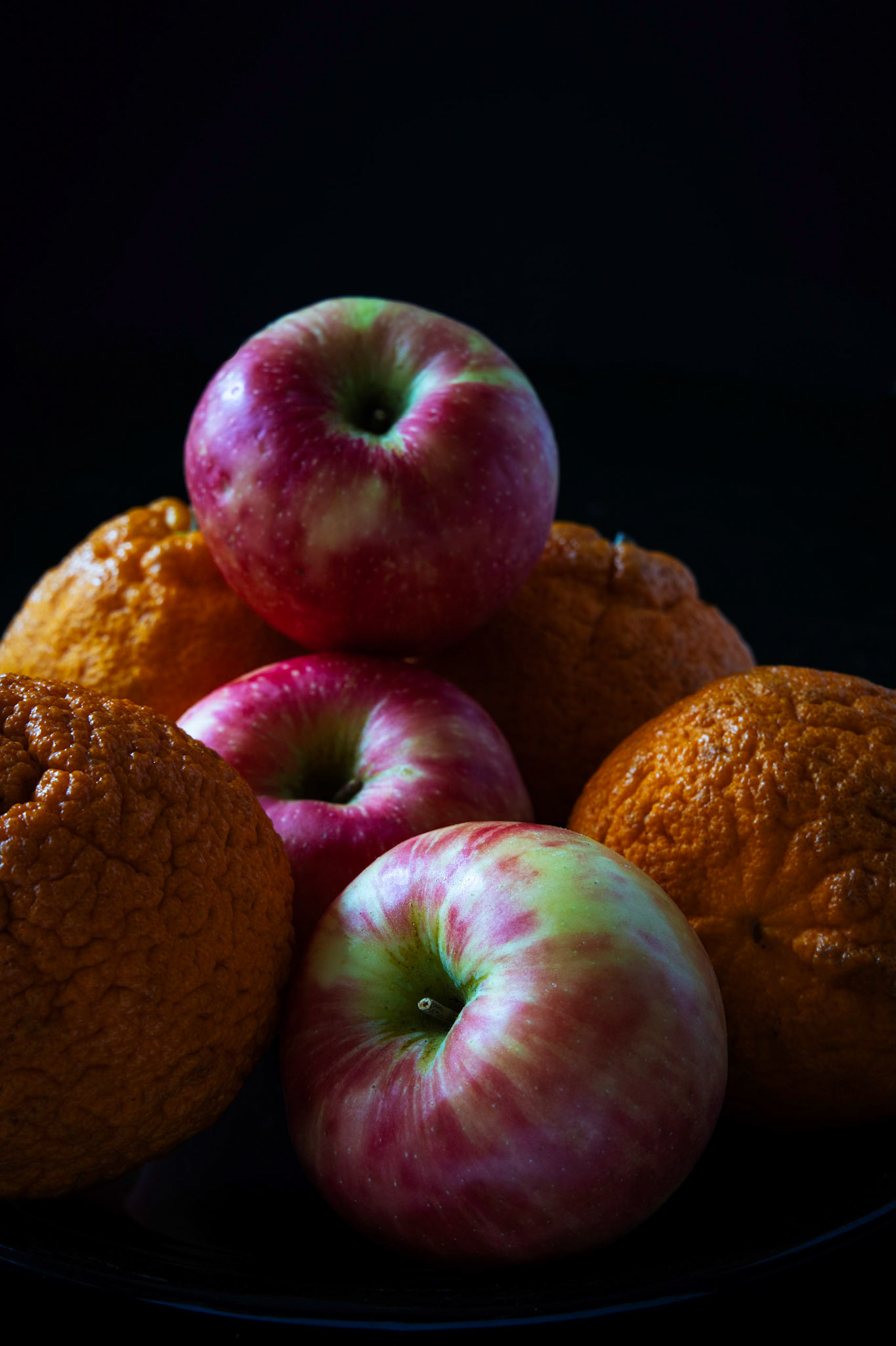 Apples and oranges on a black background