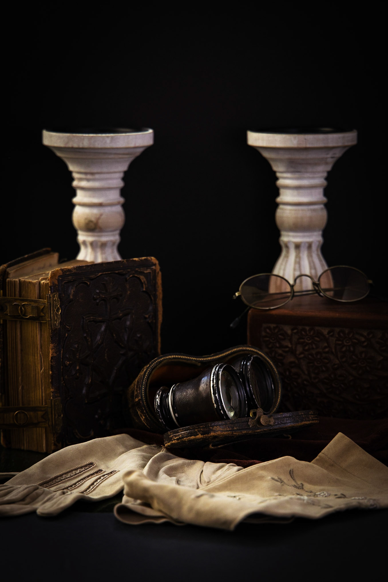 Antique opera glasses pictured with old book and glasses