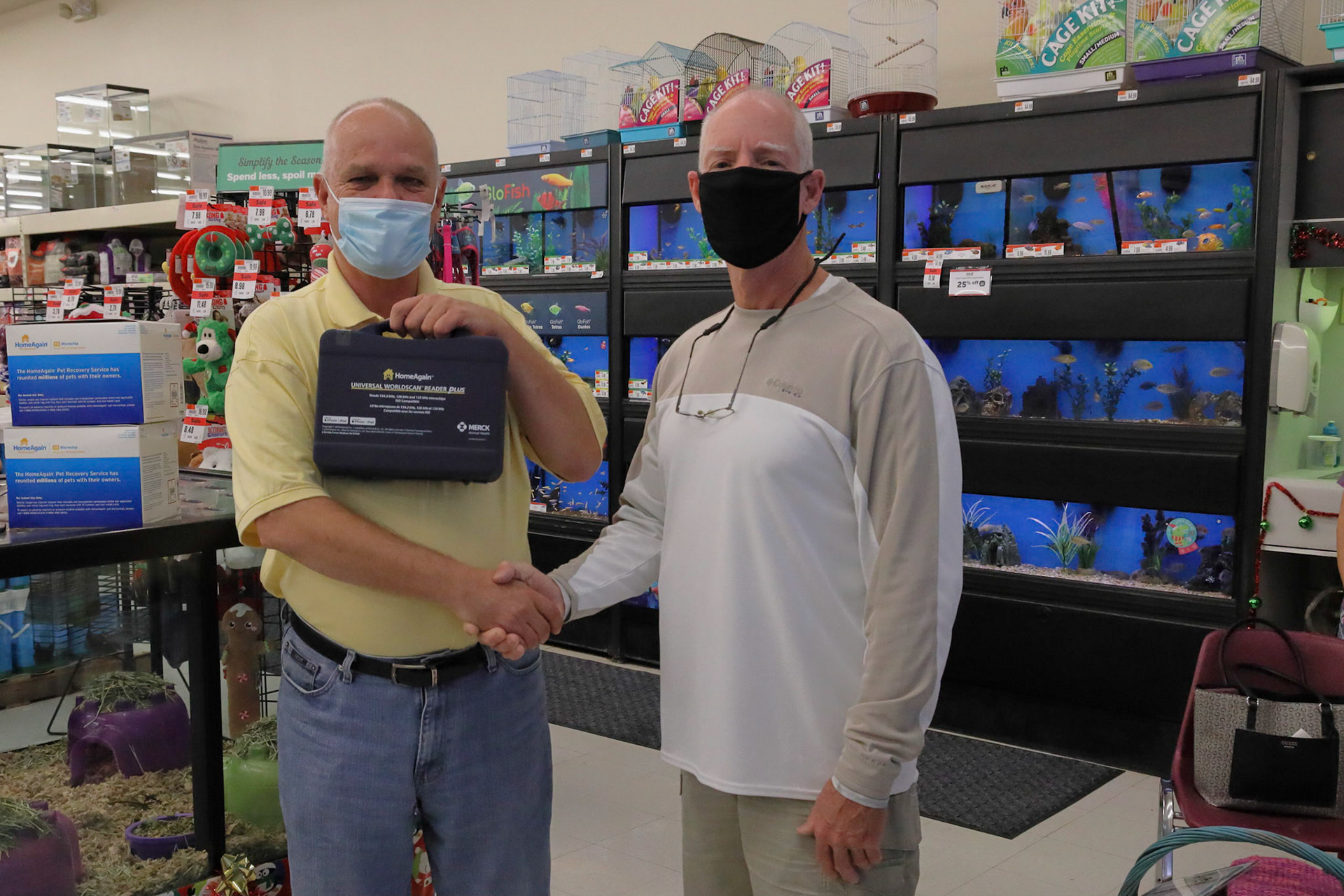 Donor presenting new microchip reader to board member and Vice President of Adopt a cat