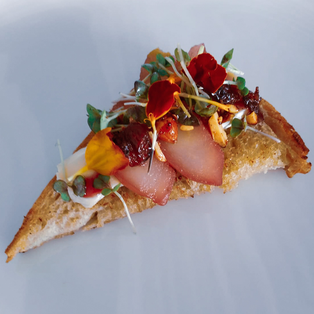 Montadito de pera caramelizada en vino tinto, mix de frutos secos y queso brie
