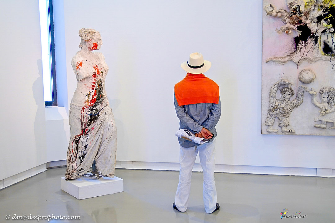 Man with orange sweater in art gallery