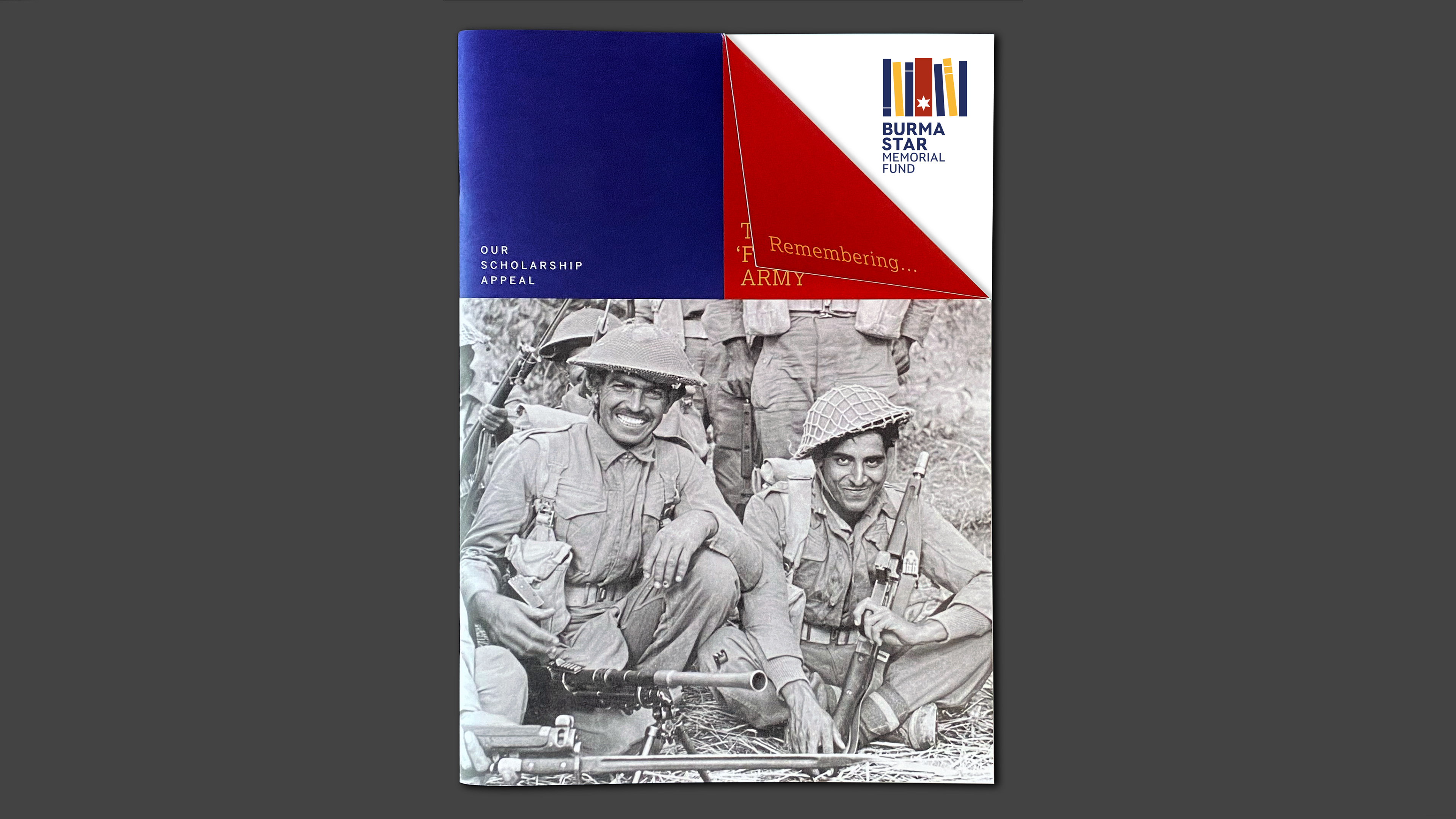 Front cover of the Burma Star Memorial Fund Scholarship Appeal brochure titled 'Remembering the Forgotten Army'. The corner of the brochure cover  is folded over as an aide memoire. 'Remembering...' is visible to the viewer while the rest of the title is revealed underneath the fold. 