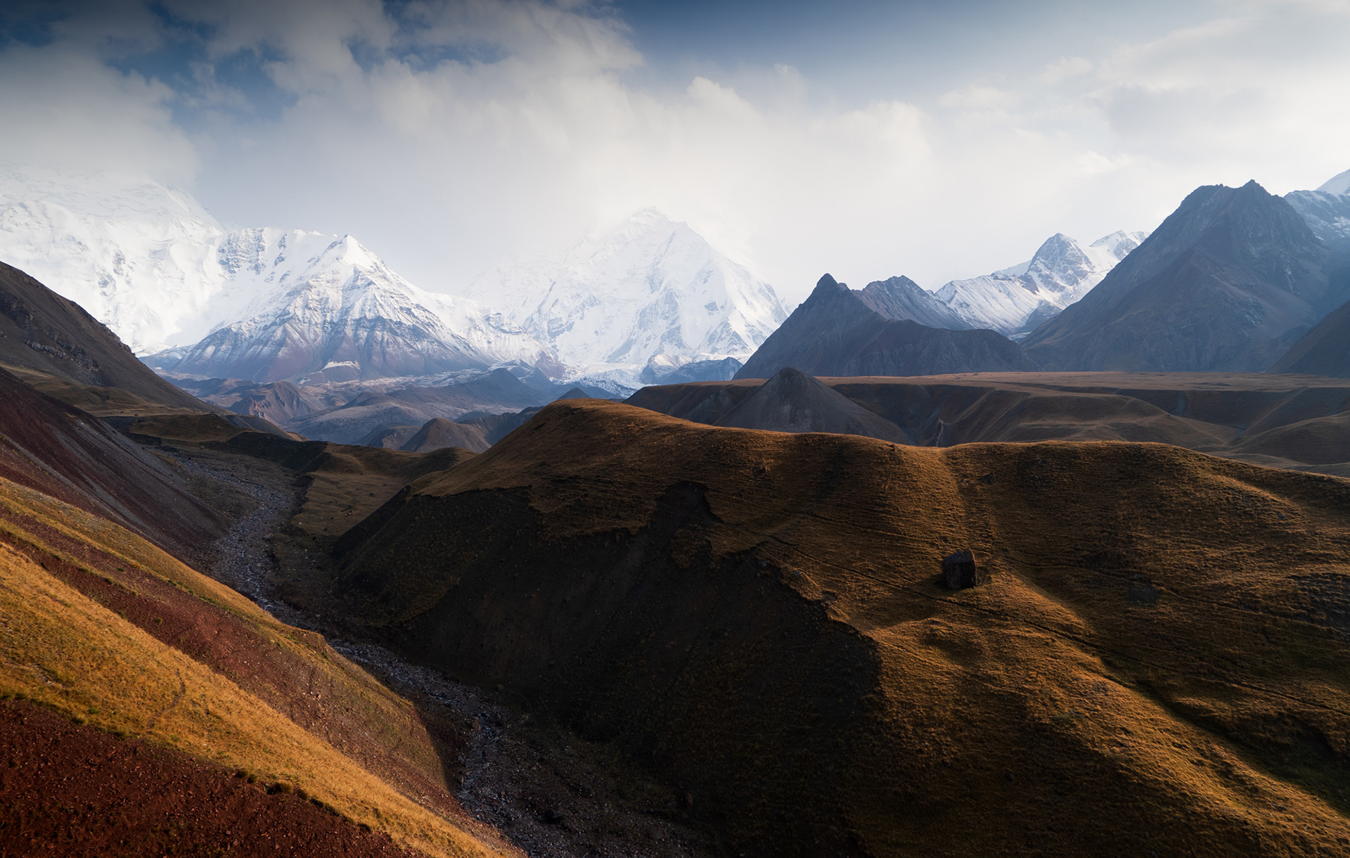 Colourful autumnal foothills in the Alay Valley in front of Peak Lenin / Ibn Sina. Pamir, Kyrgyzstan