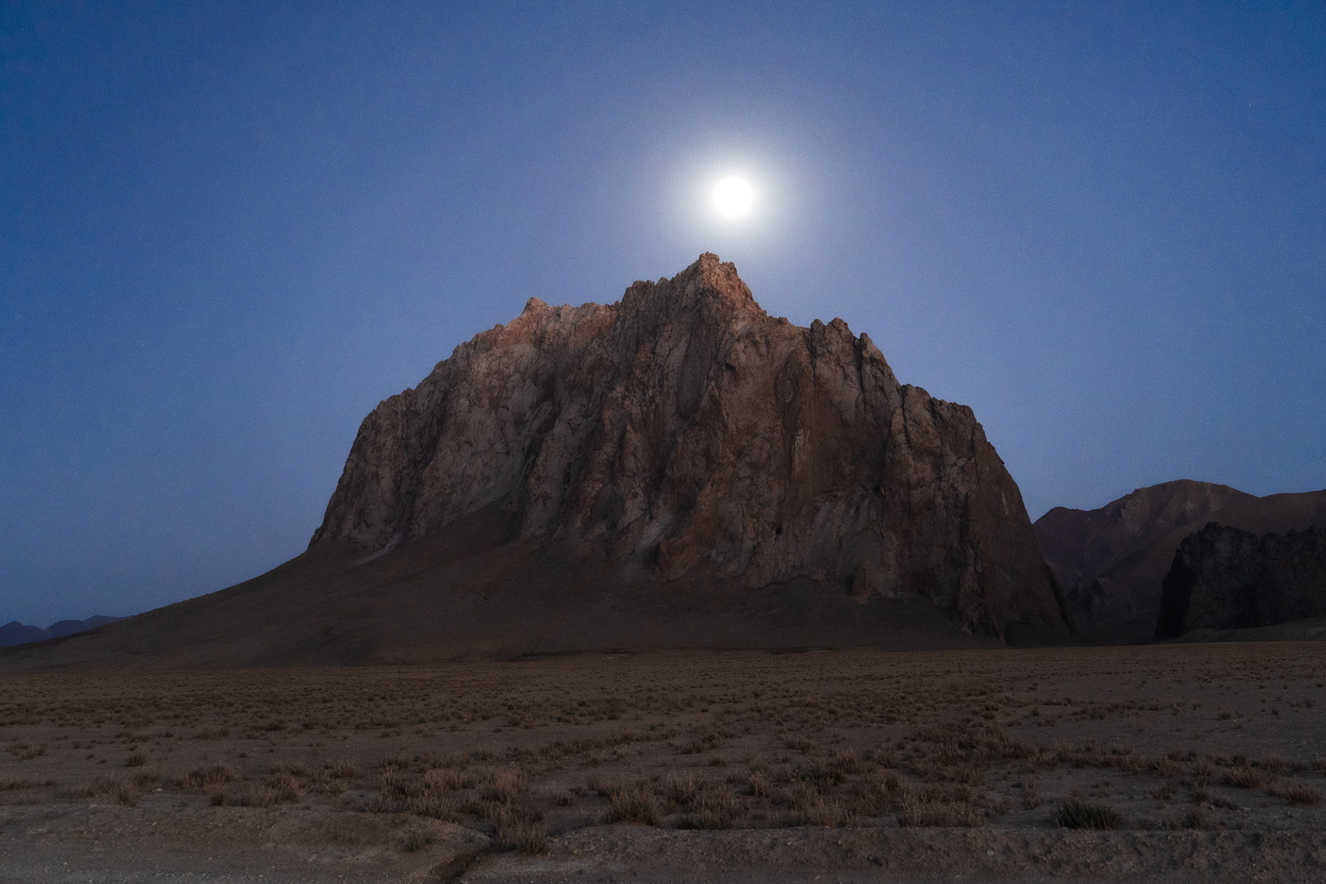 A full moon above jagged peaks of Rangkul Nature Reserve, Pamir, Tajikistan