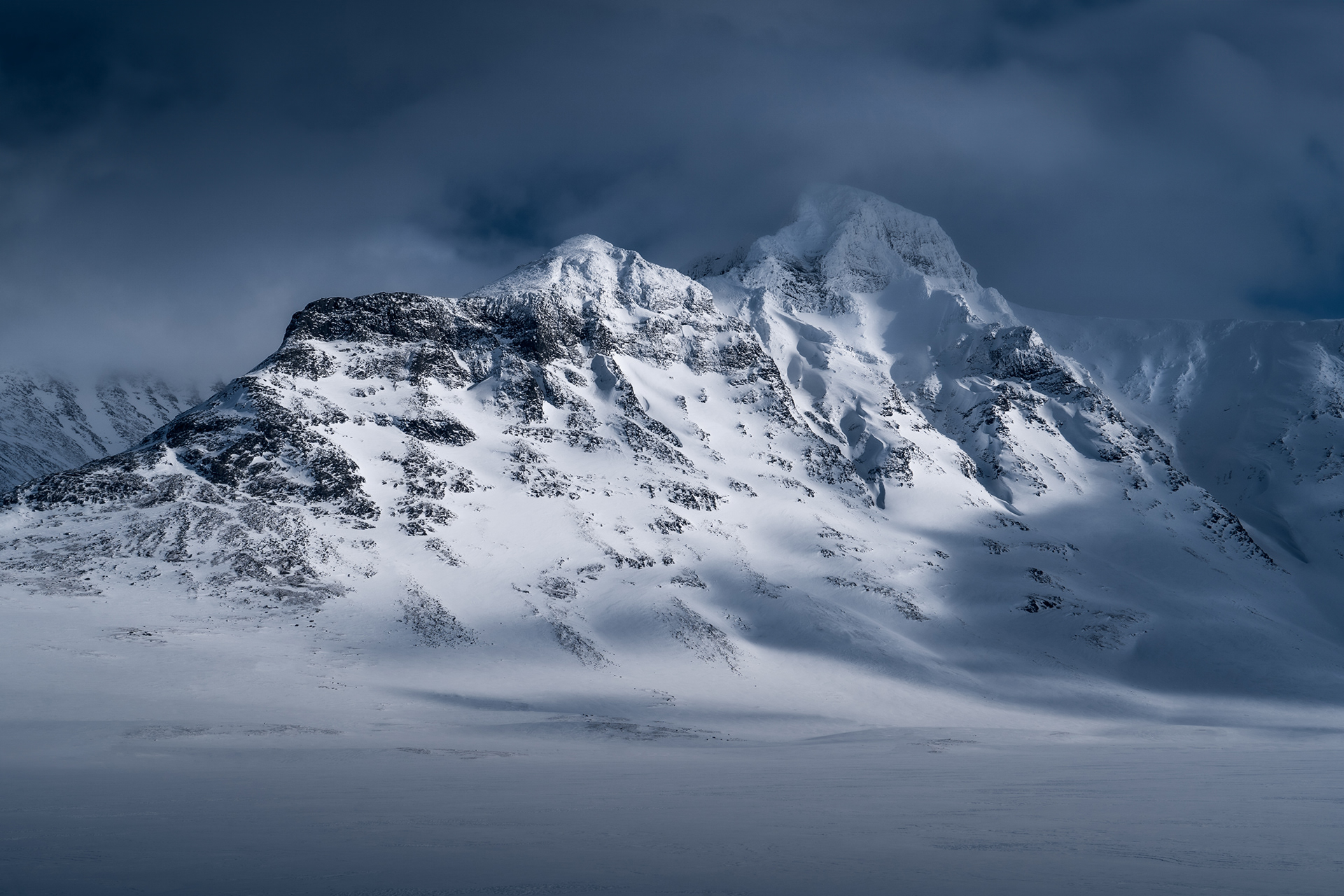 Bierikbakte Peak in Sarek National Park, Swedish Arctic, rises above a snowy, winter landscape.