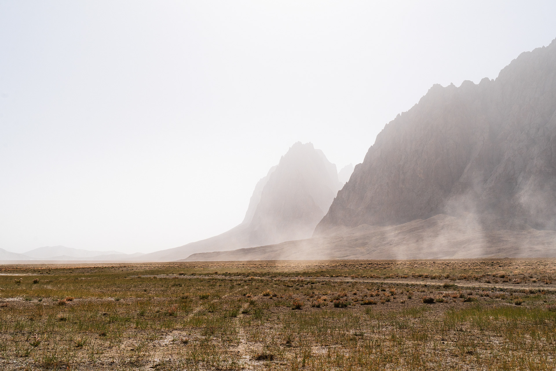 Dusty car trails and jagged peaks of Tajikistan's Rangkul Nature Reserve, Pamir.
