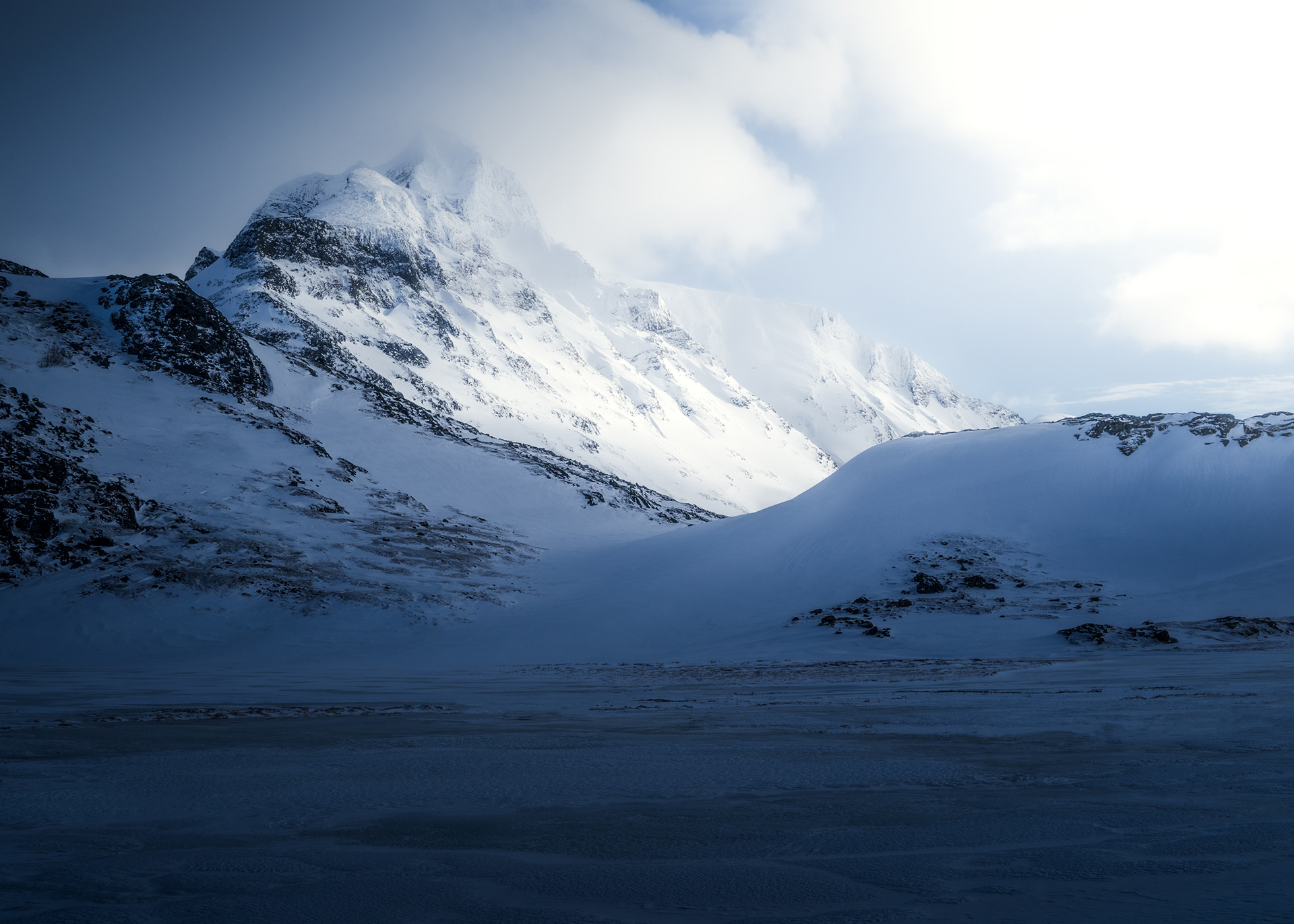 A side view of a snowy mountain Bierikbakte Peak in a winter Sarek National Park, Swedish Arctic