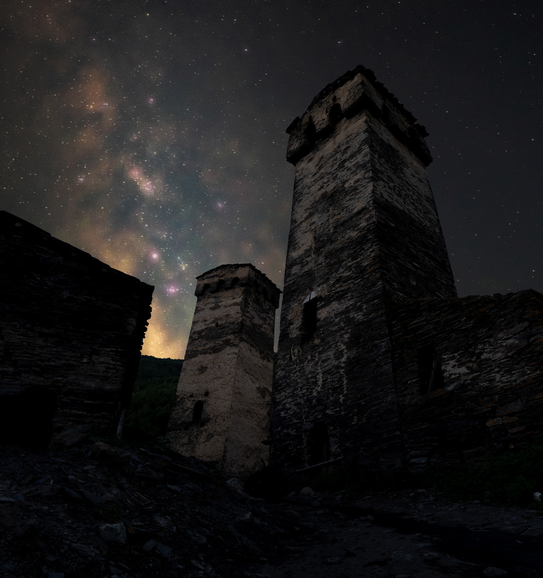 A starry Milky Way above a stone tower in an ancient village in Georgia.