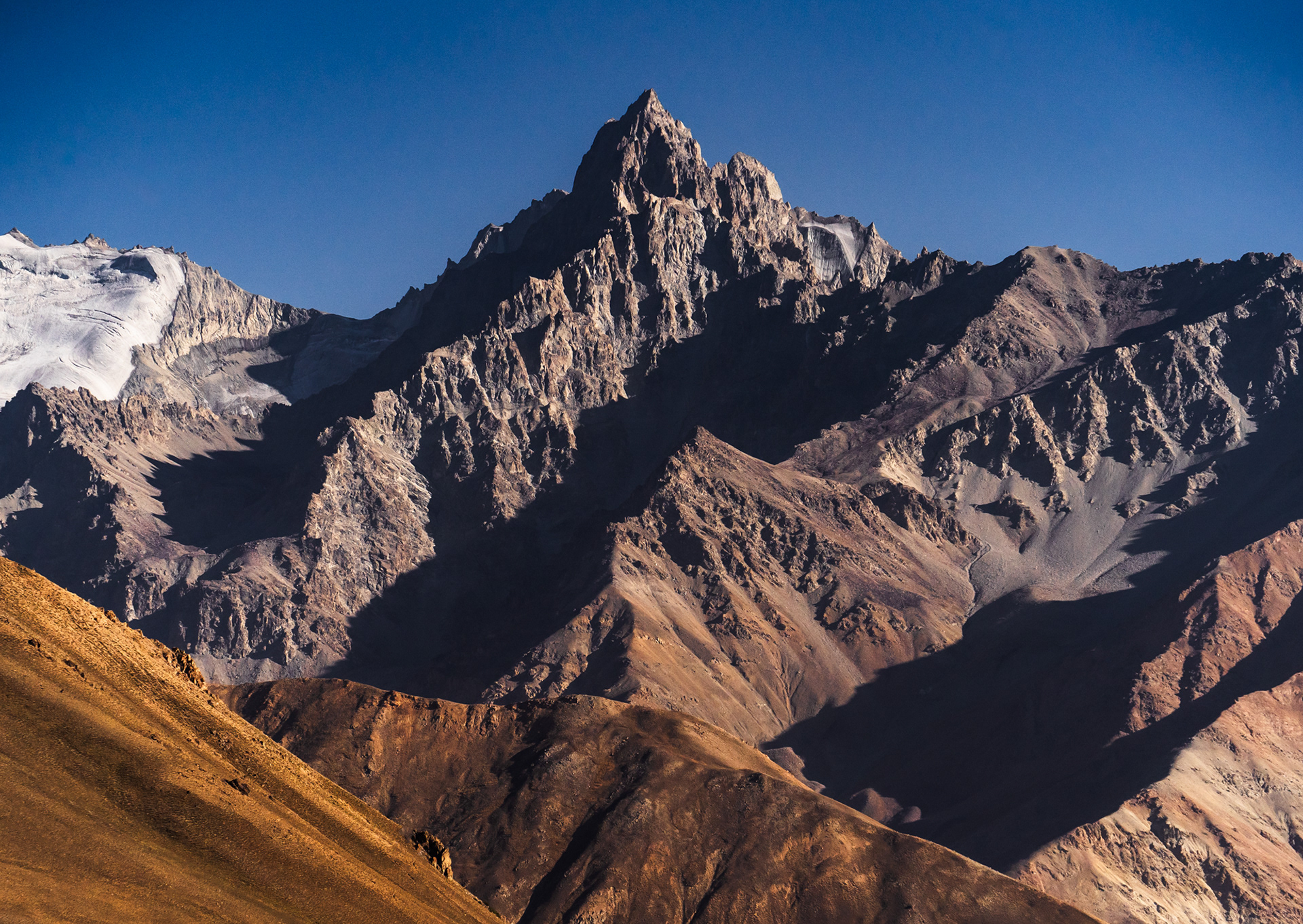 A very jagged peak rises above a harsh rocky landscape in Afghanistan.