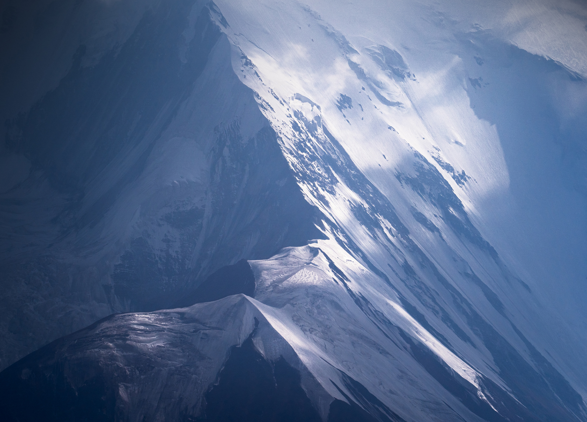 Photo of Gora Kurumdy, with strong light and shadow on the snow and ice.
