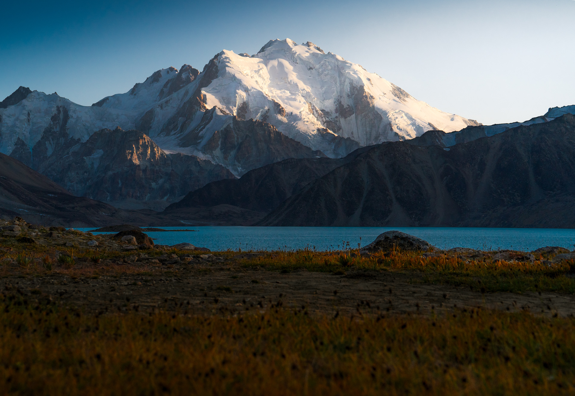 Sunset illuminates a glaciated peak in Zaroshkul Lake, Pamir.