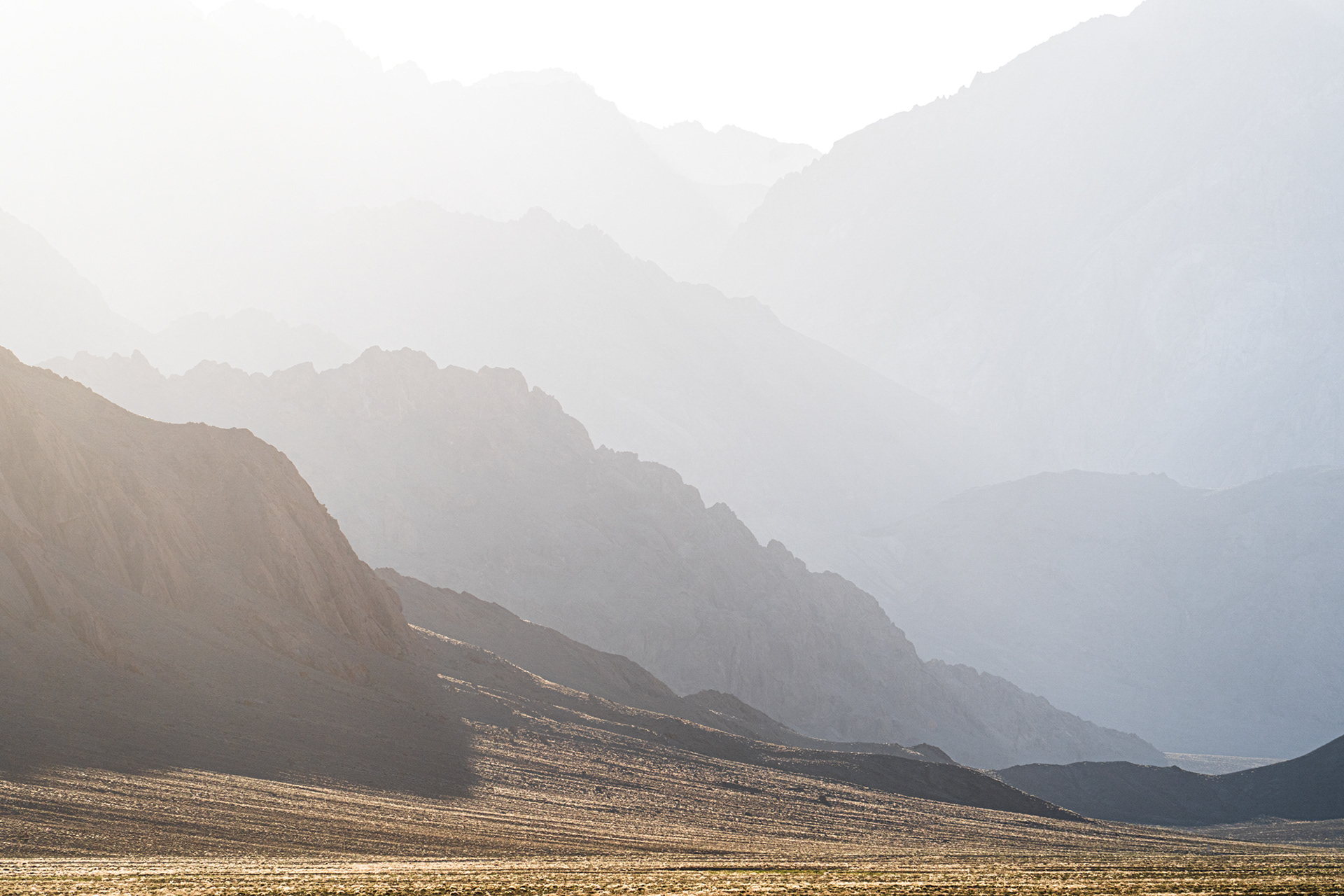 A photo of hazy layered mountains in bright sun.
