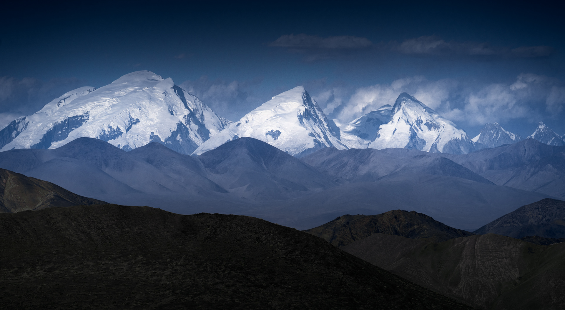  A photo of a very large, glaciated mountain in Western China that rises high above the Tajik landscape