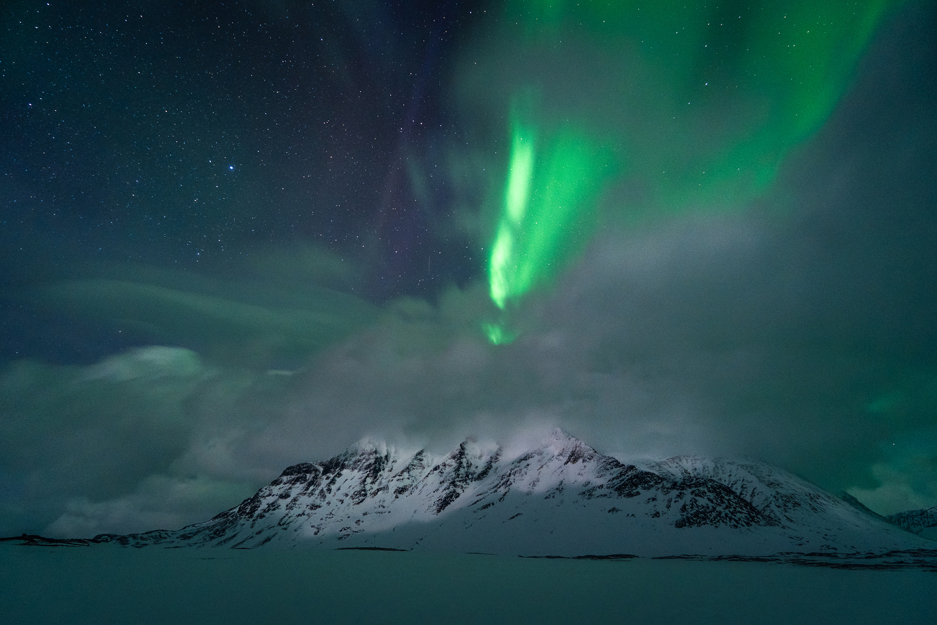 Northern Lights dance above Bierikbakte Peak in the heart of Sarek National Park, Swedish Arctic, winter landscape.