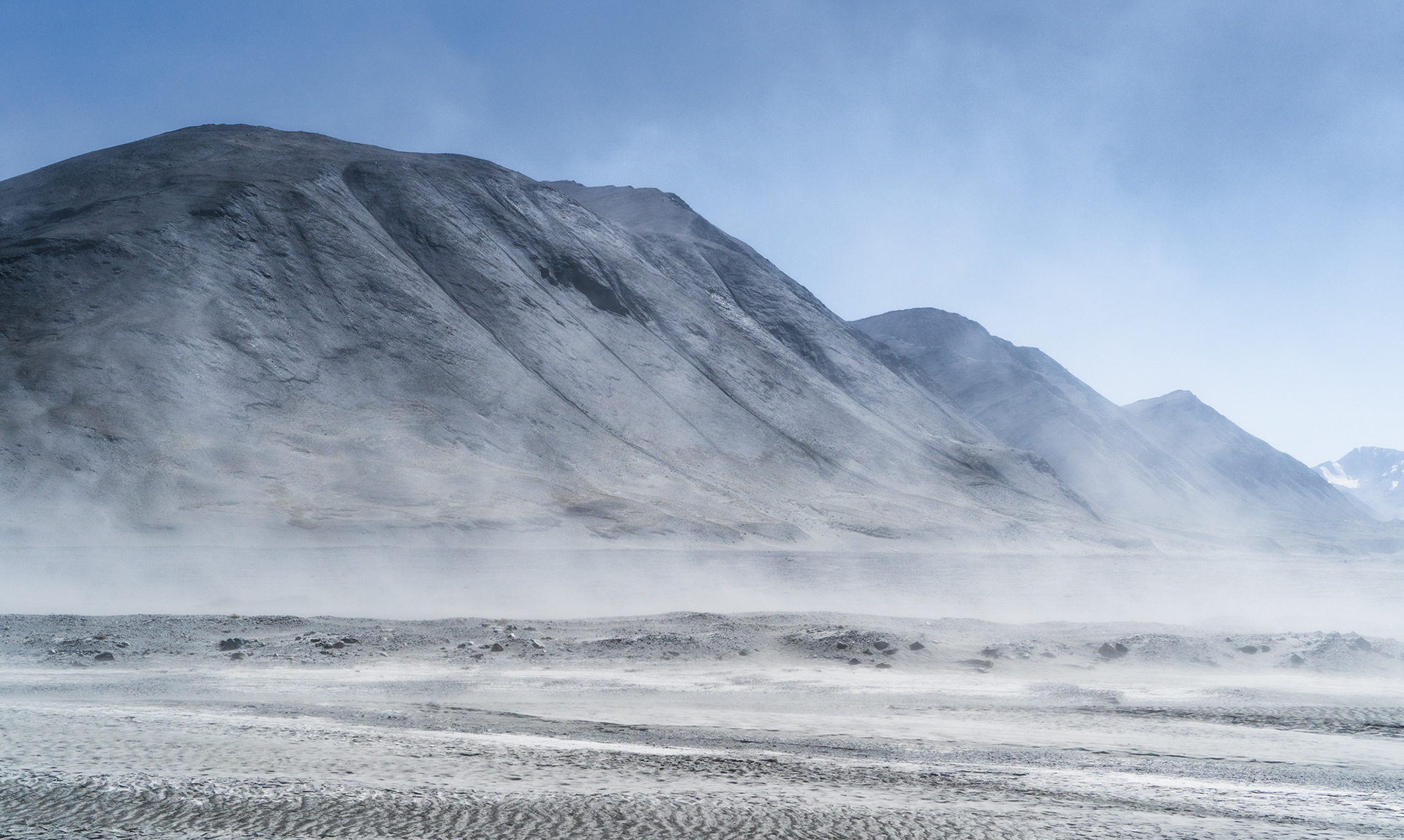 A grey, lifeless landscape visible when driving along the Pamir Highway in Tajikistan 