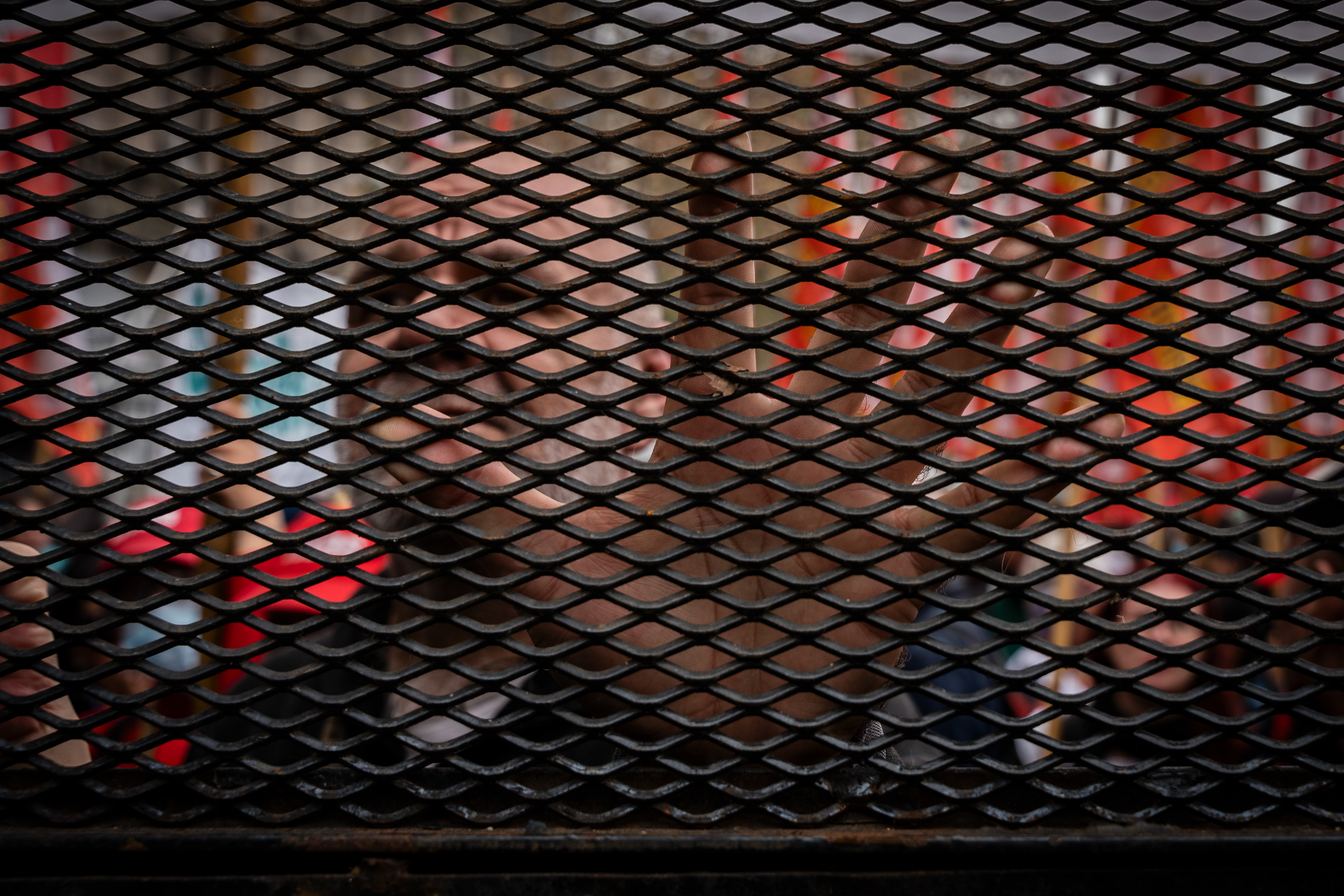 A demonstrator behind the fences put up by the police to prevent them from advancing towards the National Congress during the protest while the Senate debates Javier Milei's Ley Bases. The Senate Chamber of the Argentine Congress is debating Javier Milei's Ley Bases, which has already passed the Chamber of Deputies. Meanwhile, hundreds of thousands of demonstrators are protesting in the streets, leading to confrontations and repressive actions by security forces, in Buenos Aires, Argentina, on June 12, 2024. PHOTO: Santiago Oroz
