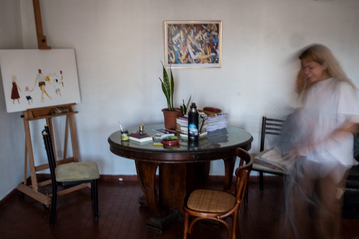 Life story. My friend Candela let me accompany her to see how she lives her life. She works in culture, militates in culture, paints what she doesn't want to forget and dreams of moving to the south. She lives with her sister Sol and her dog Ramón in an apartment in Buenos Aires that is full of beautiful light. The apartment has a good orientation, I guess west where the sun sets. The light filters through every hole, floods the shadows and at about seven o'clock in the evening tints everything in a different color. Just before it hides completely.