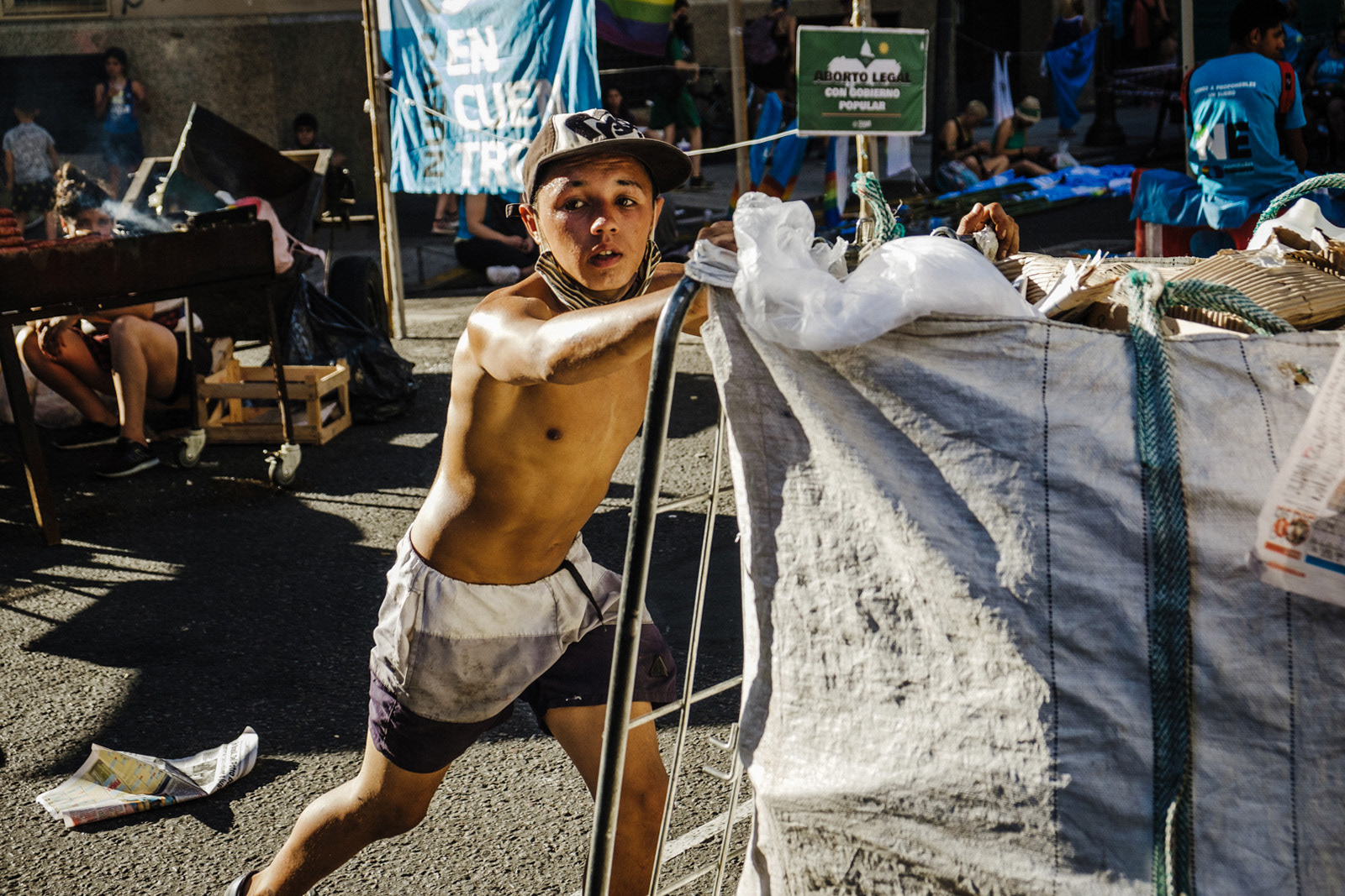 A boy pushes his cart full of cardboard as he passes through a pro-abortion legalization rally in Buenos Aires, Argentina, Dec. 29, 2020. PHOTO: Santiago Oroz.