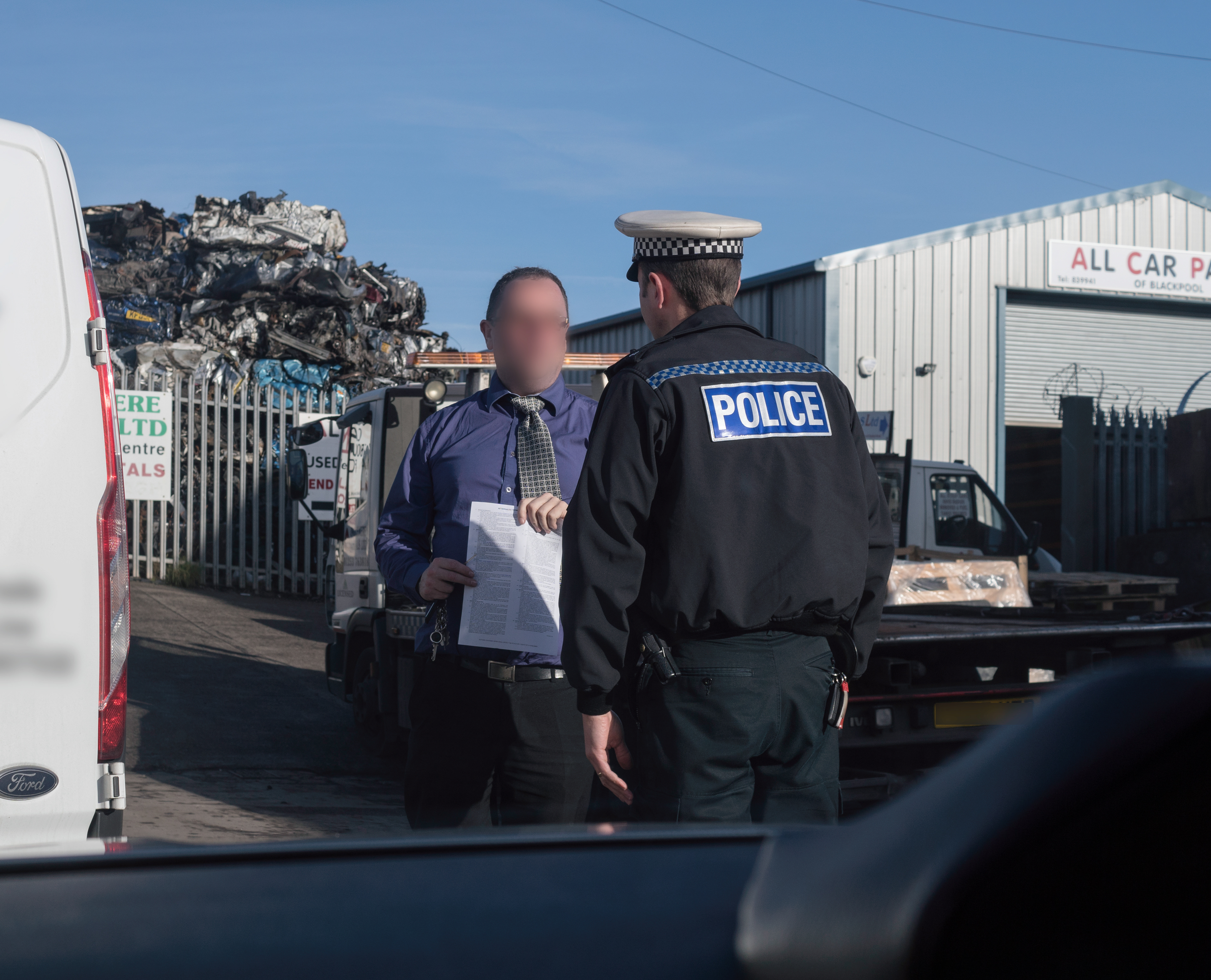 A police officer speaks to a man suspected of using his mobile phone while driving during a media ridealong