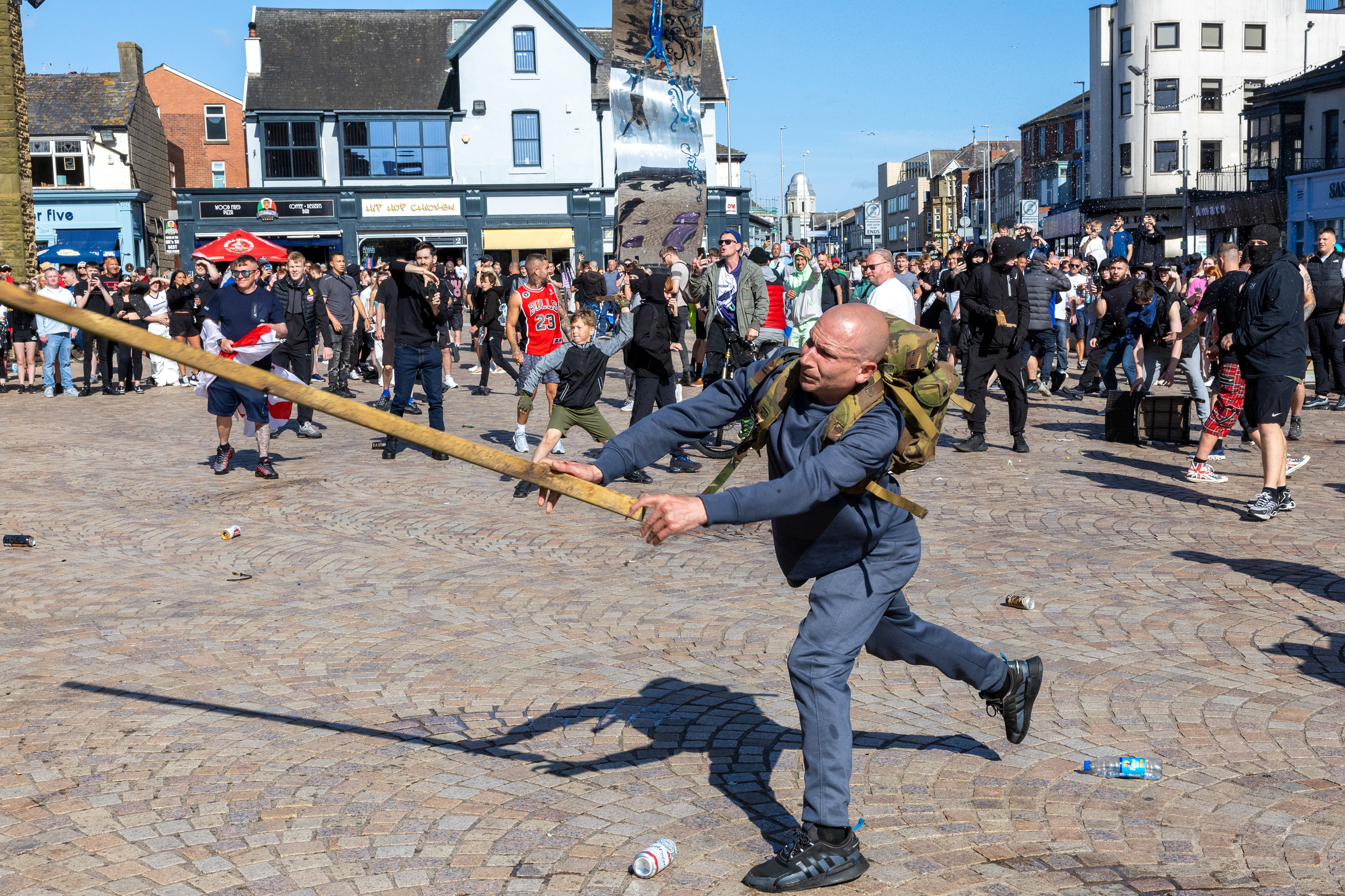 A man swings a length of wood in Blackpool town centre on Saturday August 3 2024