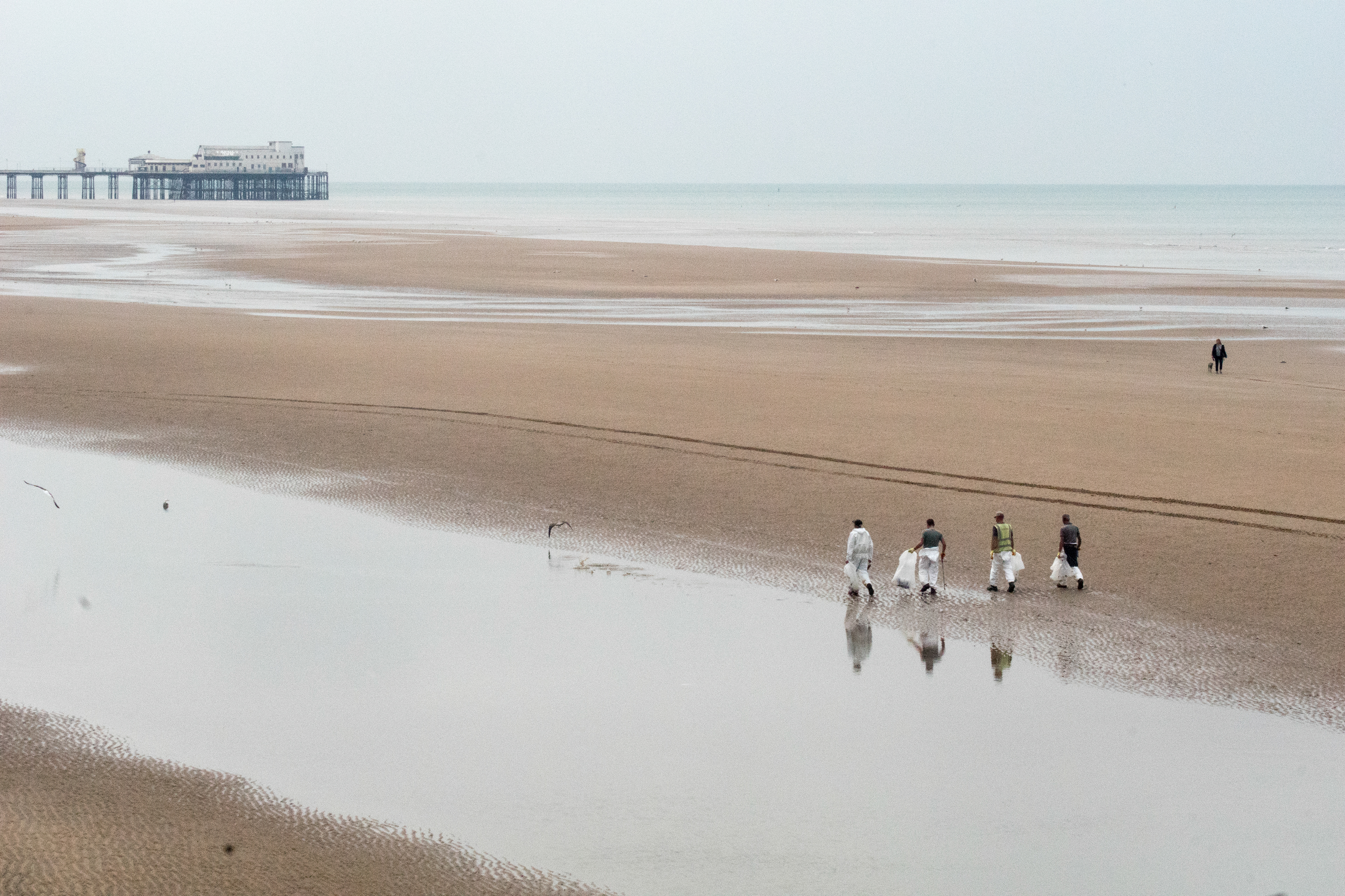 Workers clean up oil from the beach in Blackpool after an off-shore spill