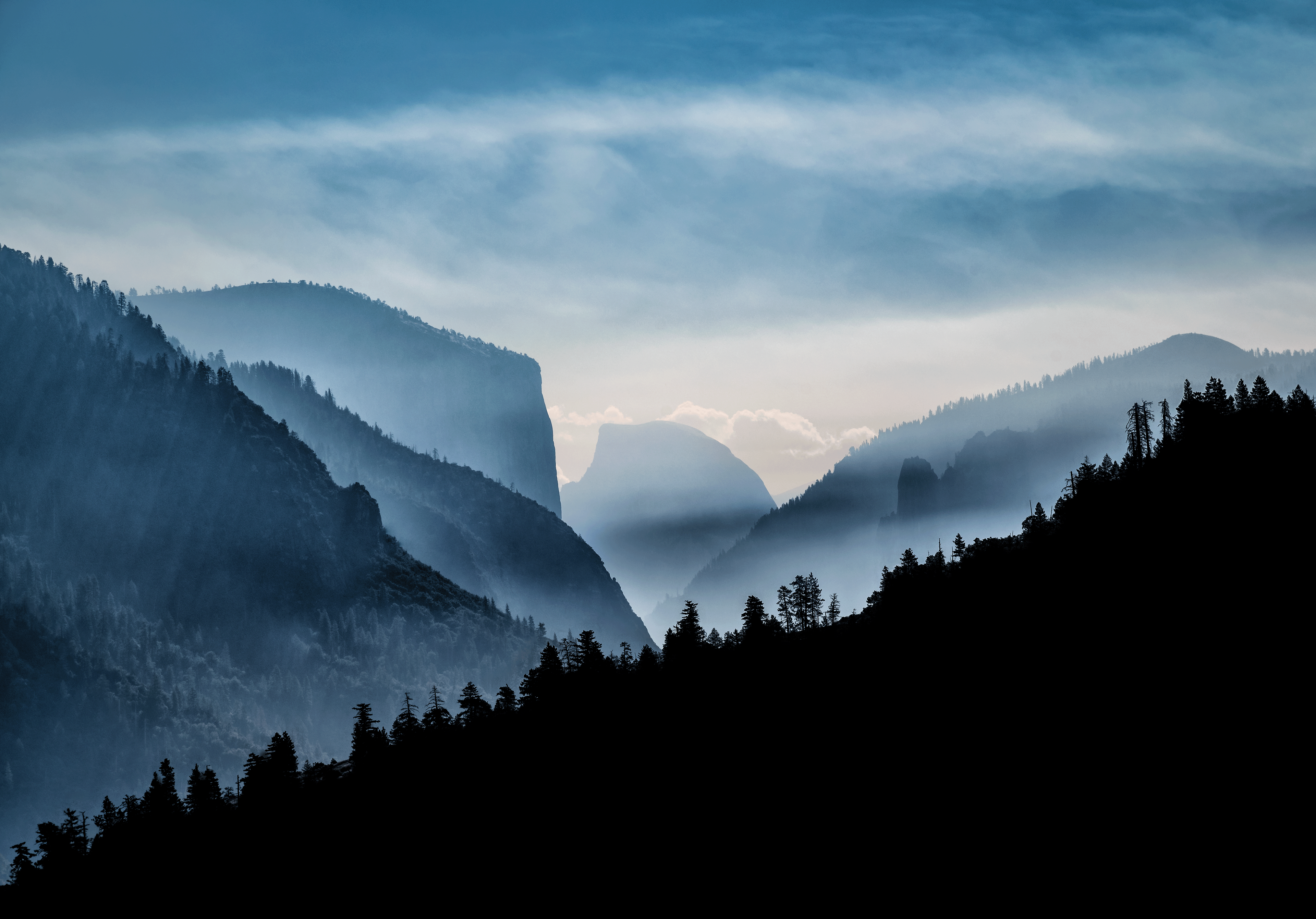 "Rising forest fire smoke through Tunnel View"  Home to one of the largest groves of sequoias in the world, mariposa grove holds thousands of years worth of nature and biodiversity. Perhaps one of the most emotional photographs for me during my travels would have been this one. The damage we create for wealth, greed and power has an ever lasting impact on our nature. Iconic views such as these are left to expose what us as humans have done to our local environment.  Sequoia groves across California are endangered by climate change. These trees are incredibly important to our historical research as well as slowing down carbon emissions. From forest fires to droughts we aren't giving this incredible species of tree or its local environment the chance it deserves to continue growing for thousands of years to come.  Slightly different photo to the last tunnel view featured post, with a slight more dramatic look. If we don't help encourage change now, these iconic views will be a token of the past and never a possibility for the future.