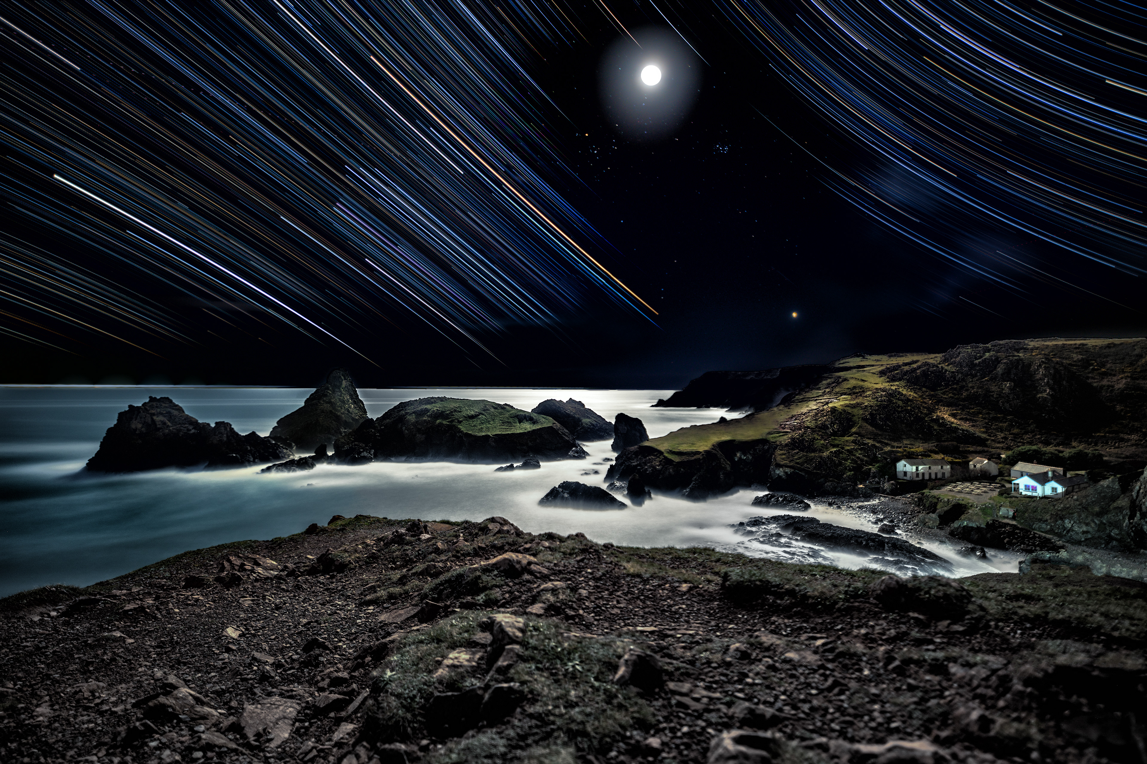 "Moonlit Cove" PT1 Kynance has always been a spot where I've wanted to try out new astrophotography techniques. From trails, to moonlight photography, to capturing Nebulas and Venus off in the distance, slow exposure sea blurring as well as the foreground this image has got a good mix of techniques. Walking out into the (semi) cold viewpoint late evening allowed me and @leahdrage_ to setup and compose with the early evening light. Unfortunately we noticed the moon would be in most of the composition making it very difficult to expose for the surroundings. Building up the photograph from several compositions would have to be necessary to bring out every detail in the image. This is one of the most unusual star trails I have taken part in, it's not normal to encourage the moon in a photograph, especially when you are focusing on staining the night sky with colourful trails. By isolating the trail of the moon I was able to get better details of some Nebulas which would be hidden away by the moons trails within a couple of hours. Copywrited © Alexander Harrison 2023