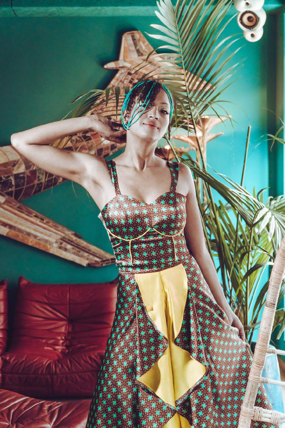mujer usando un vestido estampado con diseño de inspiración africana en colores turquesa, bordeaux y amarillo