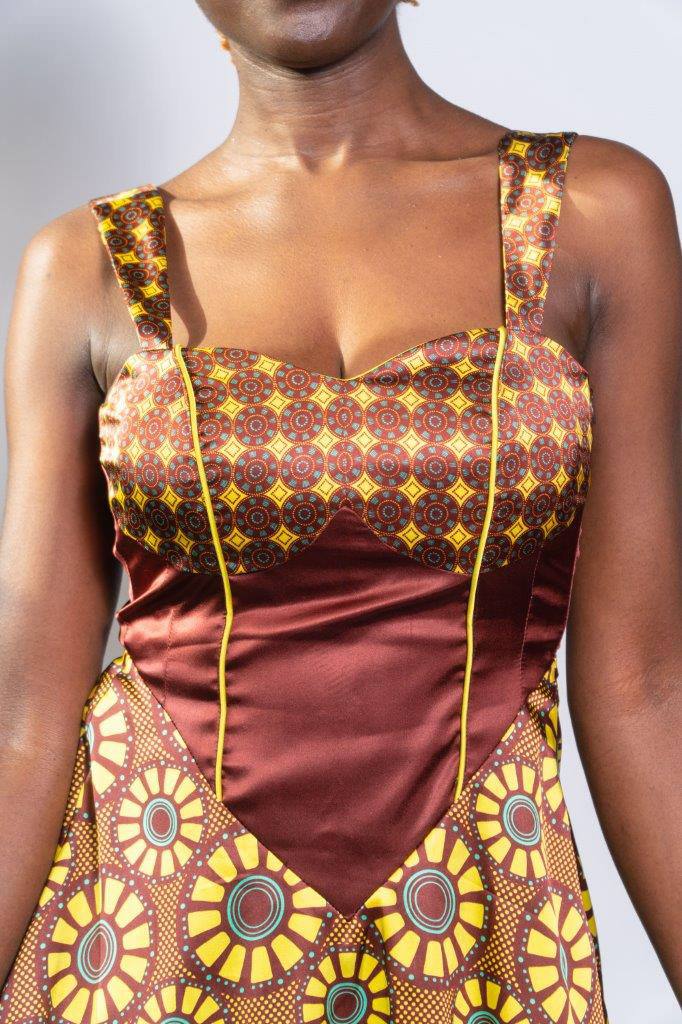 detalle parte superior frente de vestido estampado con diseños de inspiración africana coordinados, en colores bordeaux, amarillo y turquesa