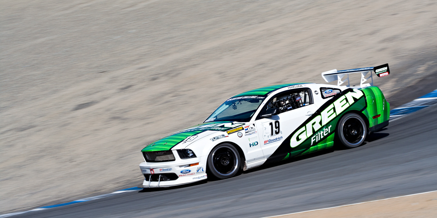 Go Green..Ford Mustang with Green details racing the track...Laguna Seca Raceway, CA