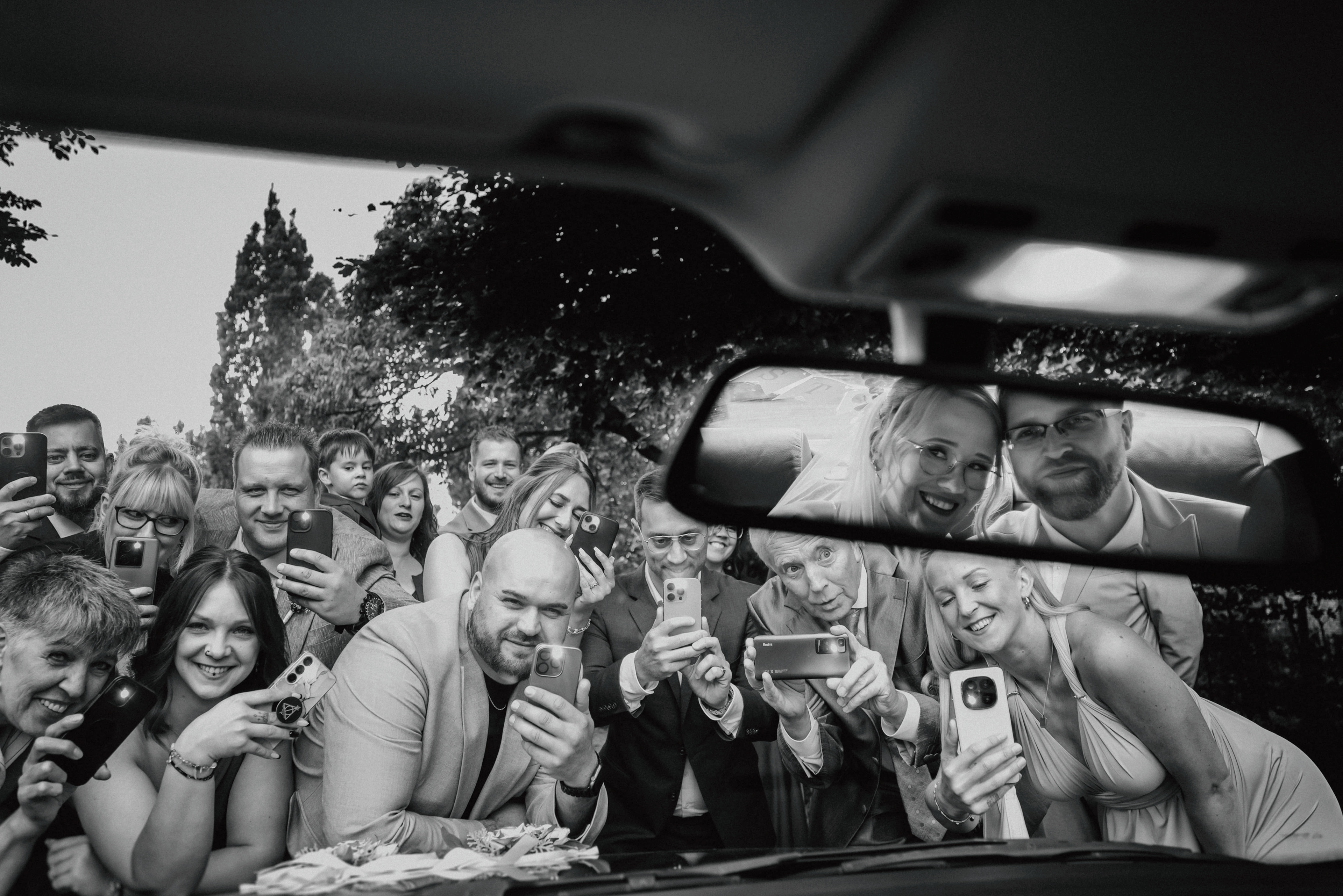 Freunde Fotografieren das Brautpaar mit dem Smartphone 