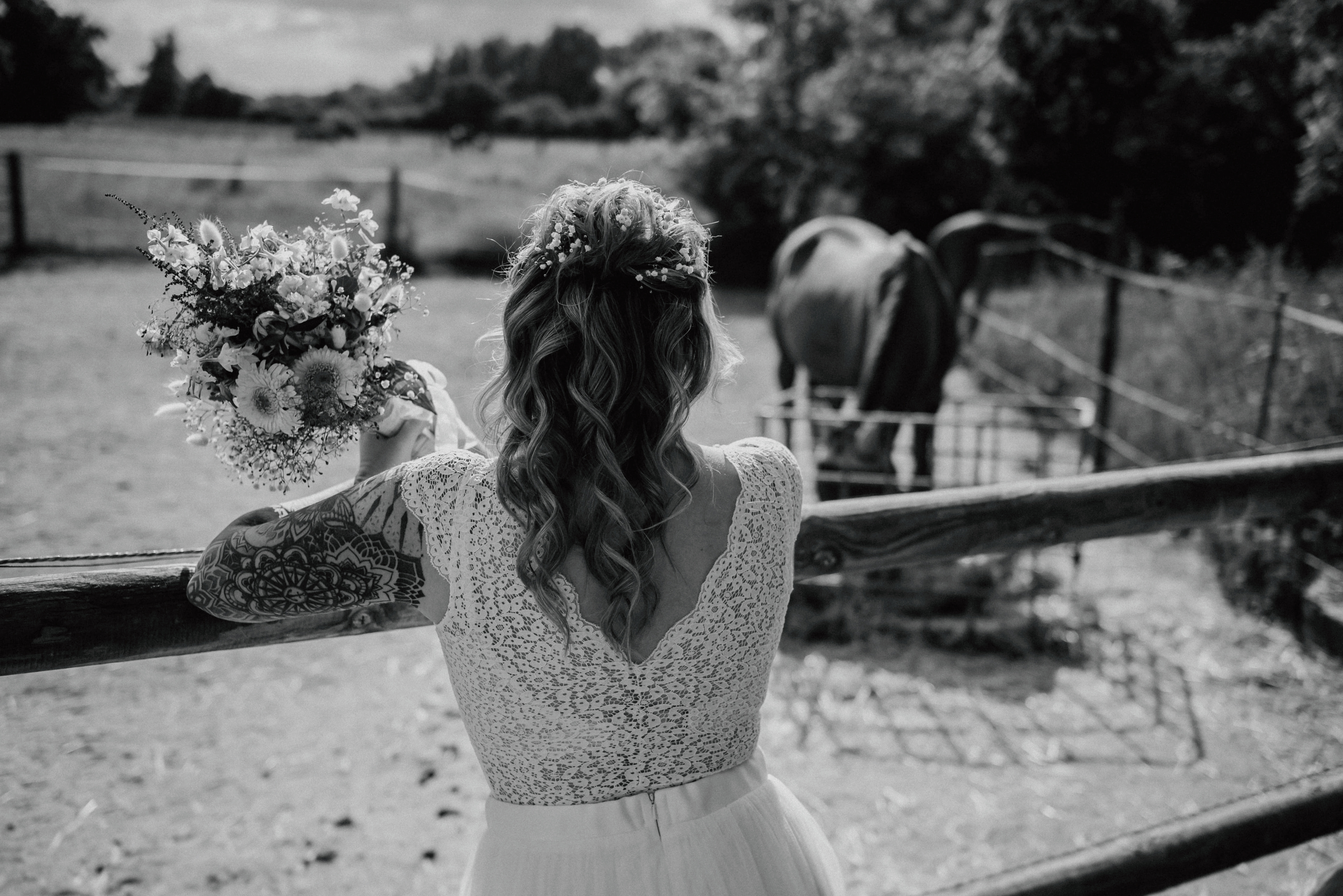 Braut von hinten, blickt auf ein Pferd