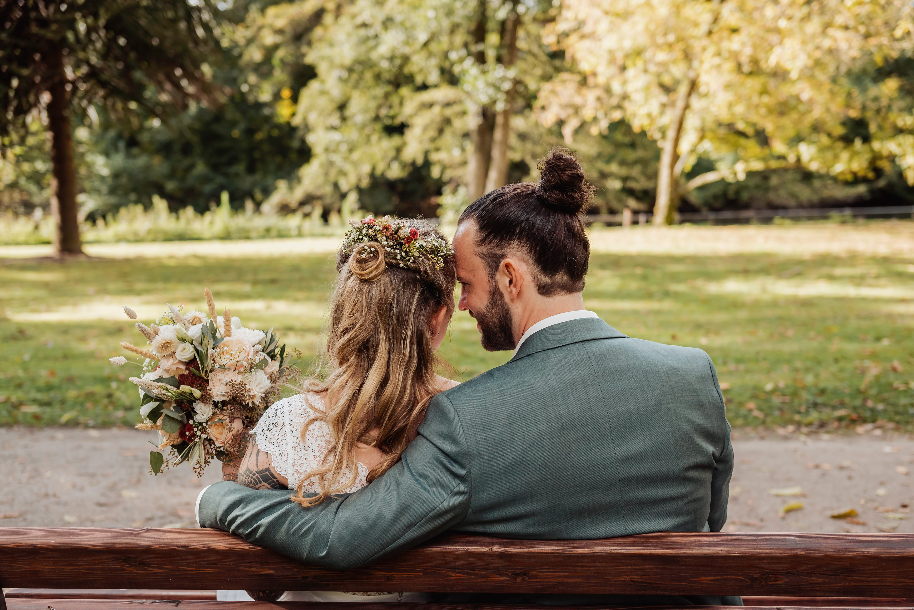 Brautpaar im Park sitzen auf einer Bank