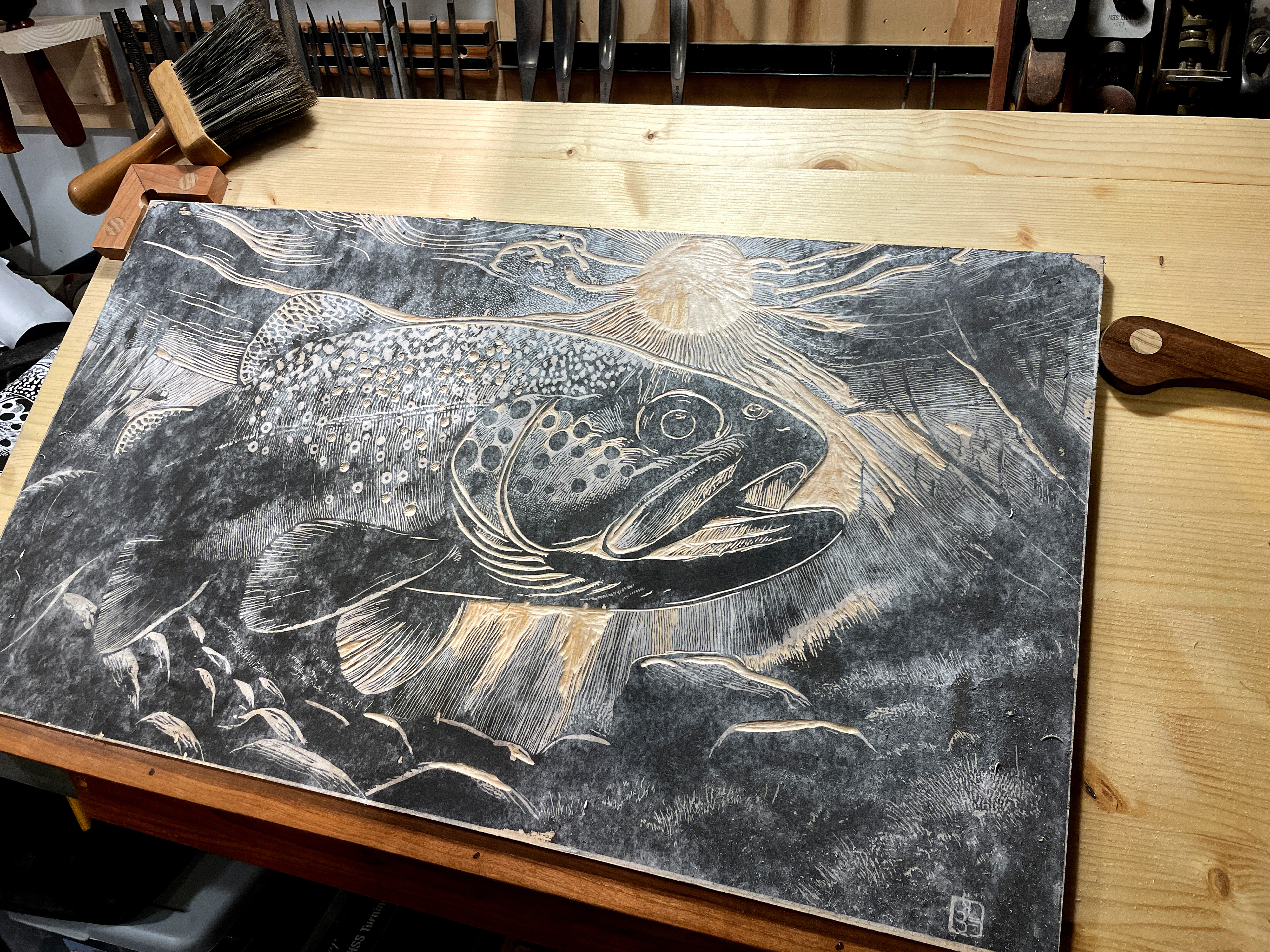 Trout on the carving table, the black is from the paper design glued to the block