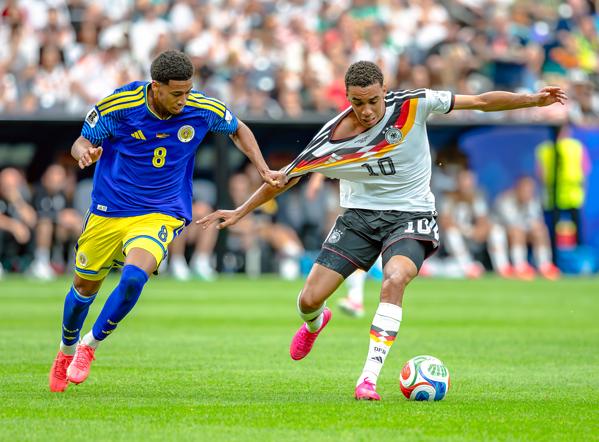 Curaçao midfielder Livano Comenencia and Germany attacking midfielder Jamal Musiala