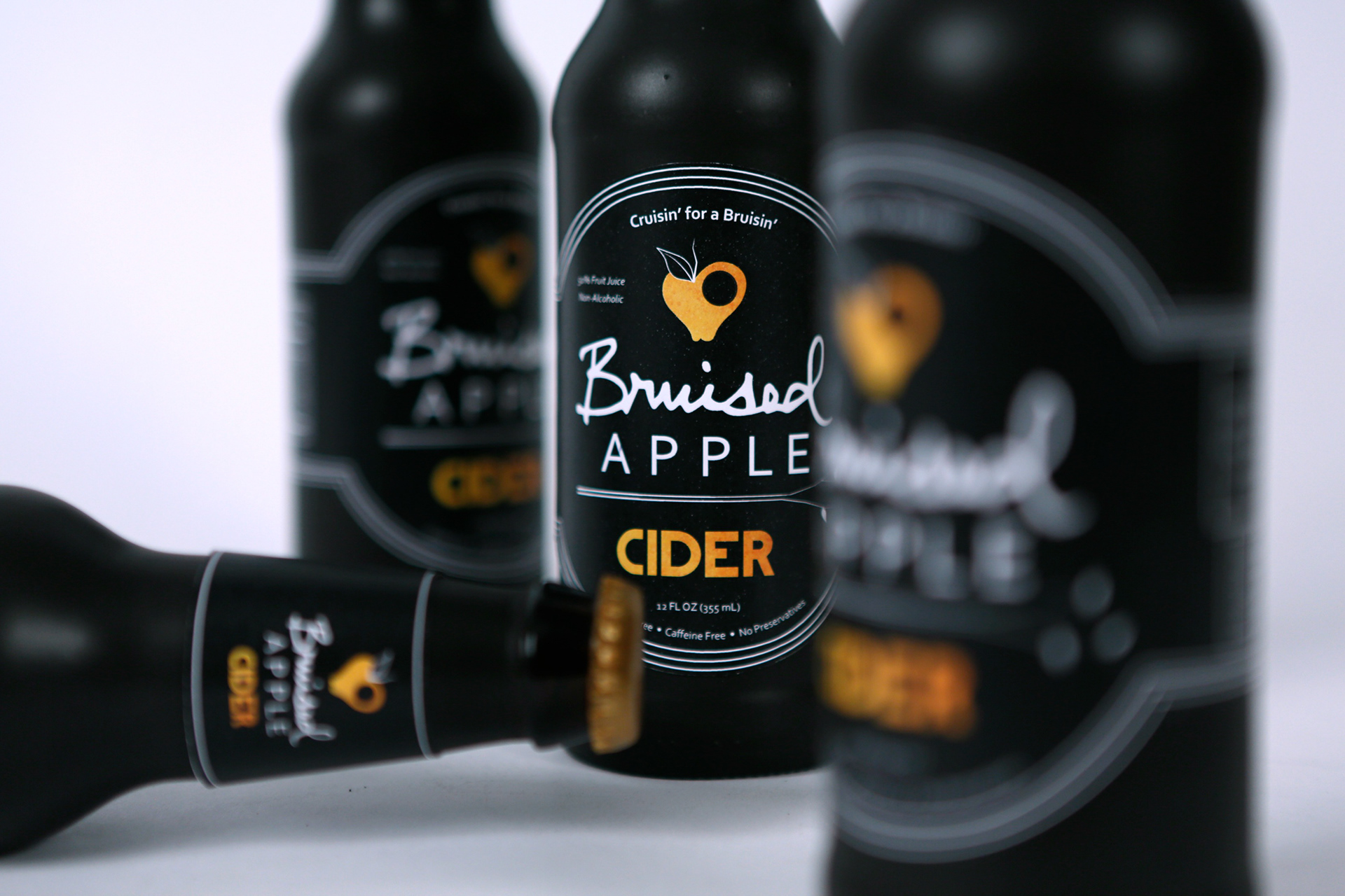 Packaging for a fictional apple cider brand, "Bruised Apple Cider"