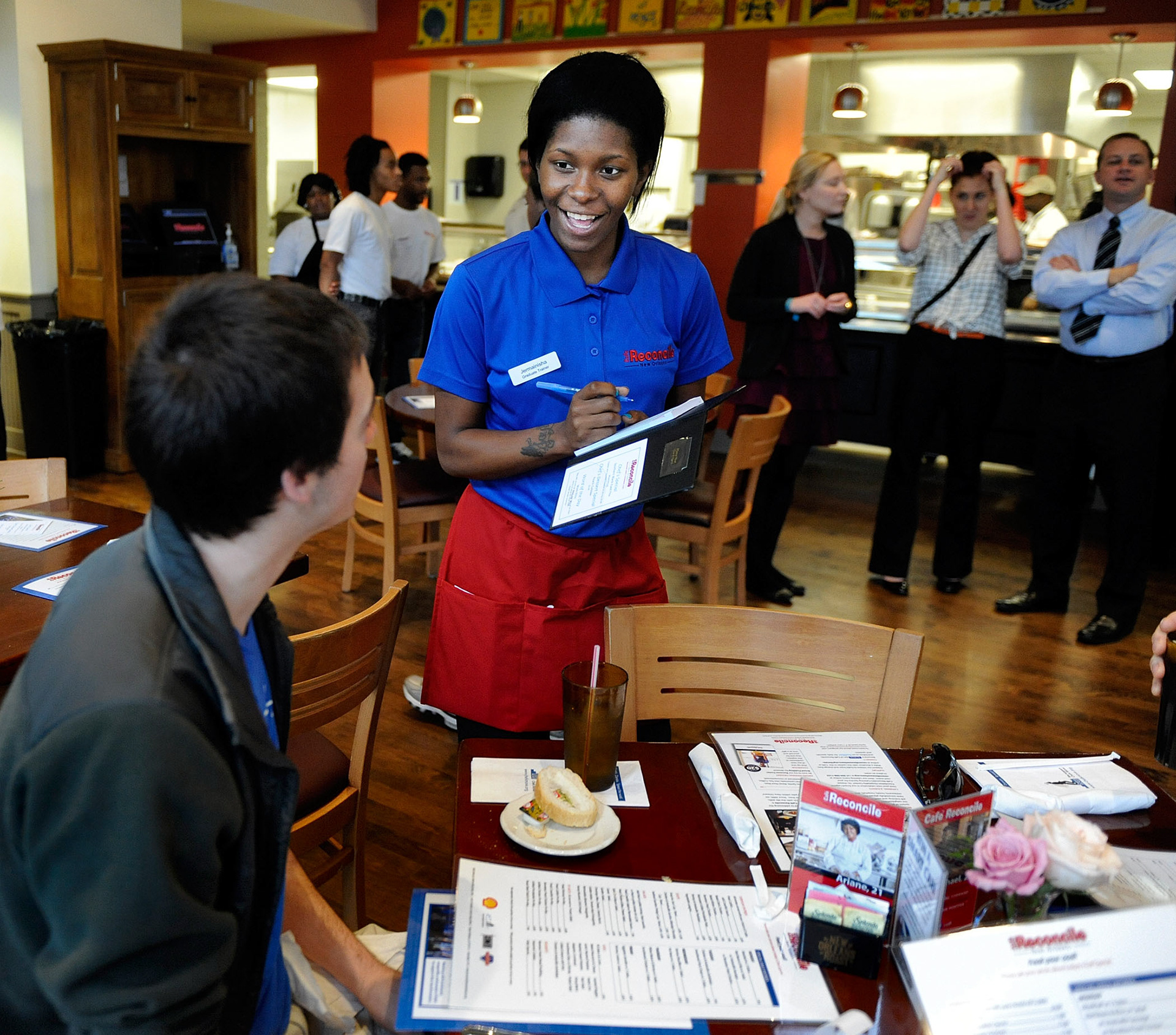 Waitress Jermainisha Youngblood takes an order from customer Tom Mayer Monday at Cafe Reconcile.