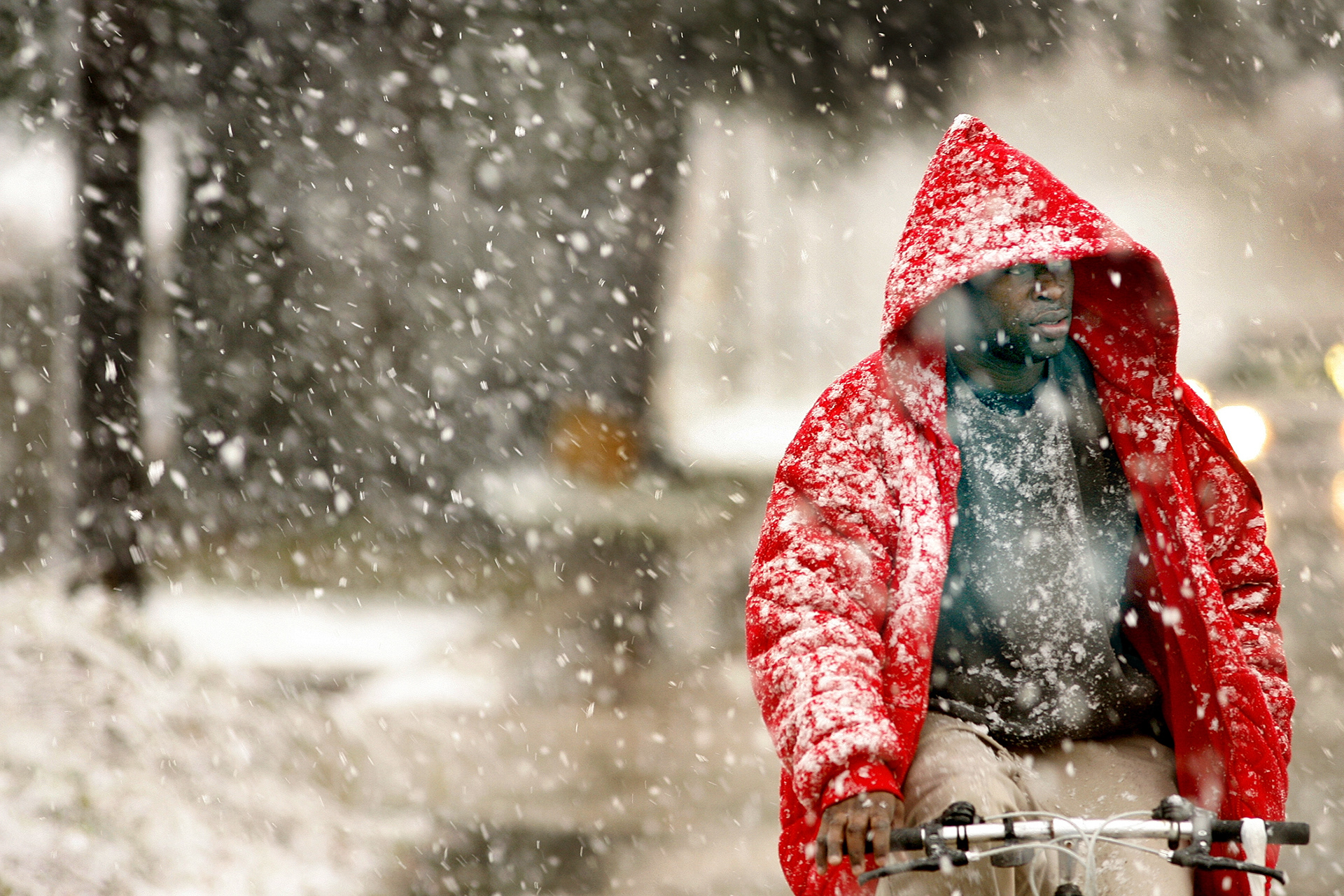 Isaac Miller pedals down Paris Avenue in Gentilly Thursday morning as the snow falls steadily.