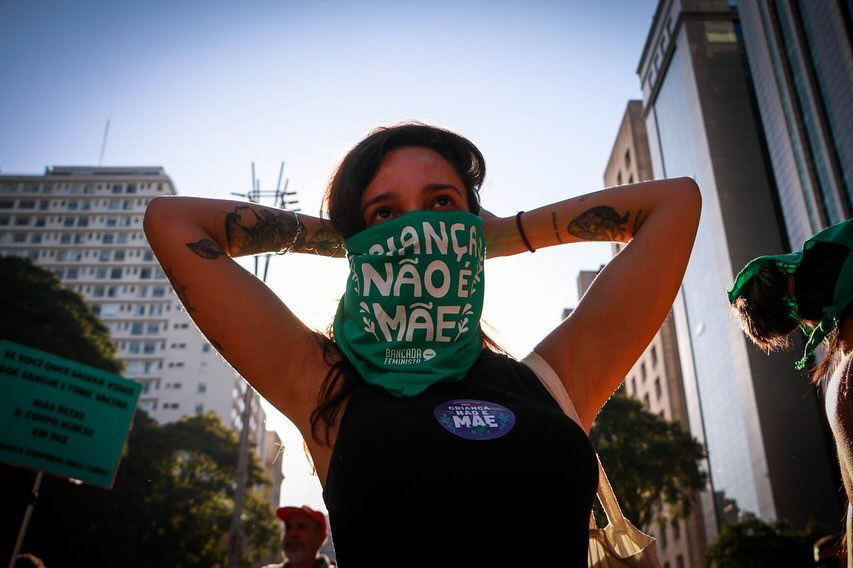 Lenço 'criança não é mãe' utilizado por manifestante em ato, agosto de 2024.