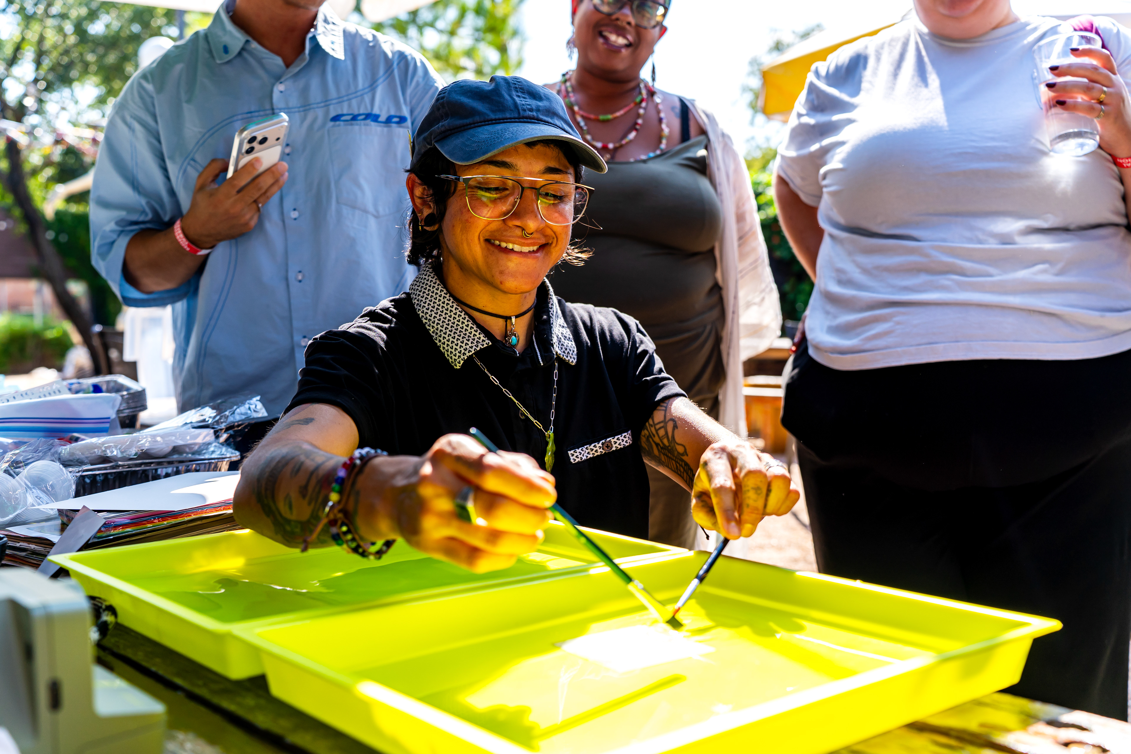 Renee Medina uses paintbrushes to create motion on the emulsion layer of a Polaroid during her emulsion lift workshop at Harvest House during Polacon on Sept. 26, 2025. An emulsion lift is the process of removing the light-sensitive emulsion layer of a Polaroid and putting it into warm water. The layer would then be put onto a different surface.